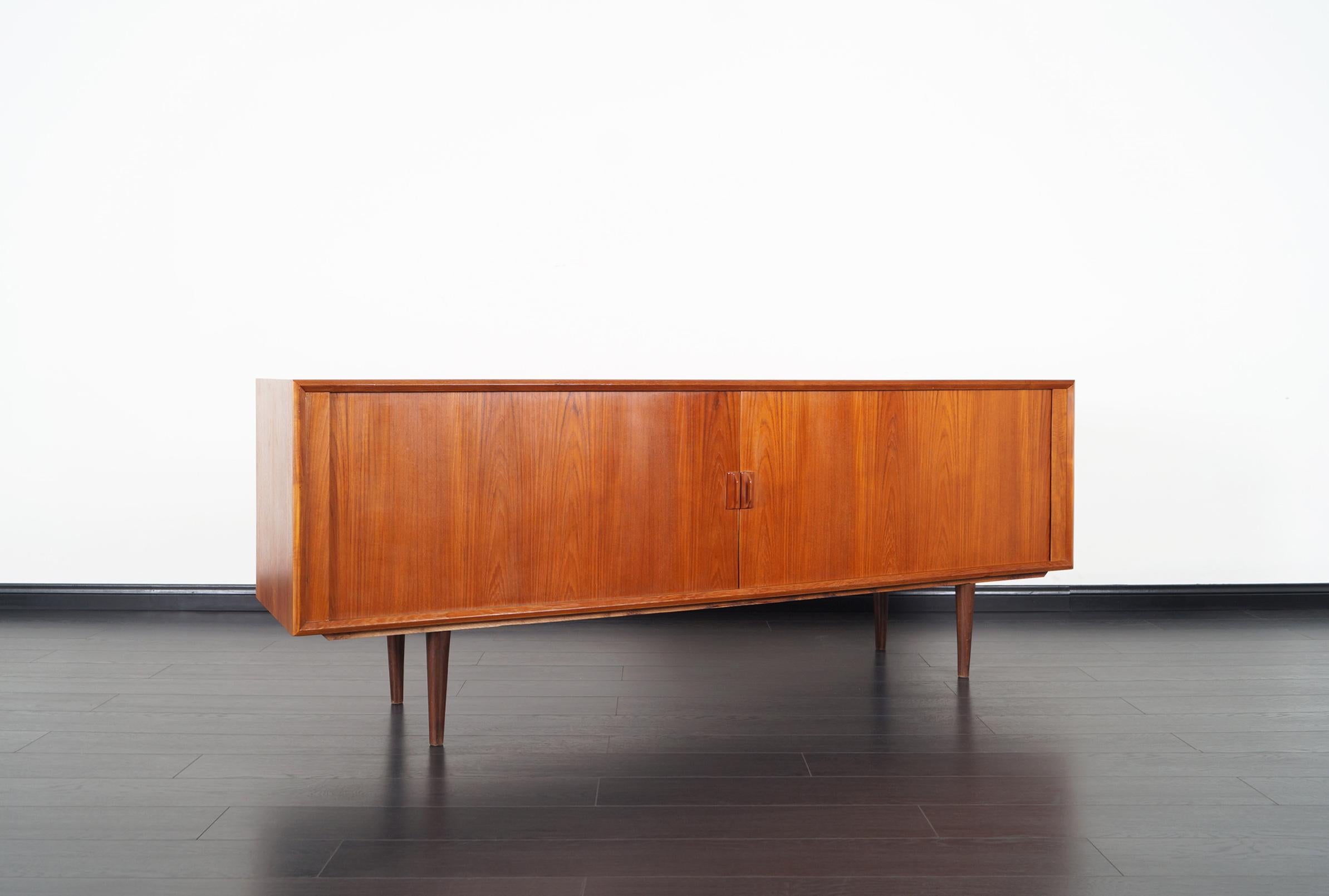 Fabulous Danish modern teak tambour door credenza designed by Svend Aage Larsen for Faarup Møbelfabrik. Features two sliding doors that reveals four dovetailed trays and a total of three adjustable shelves.