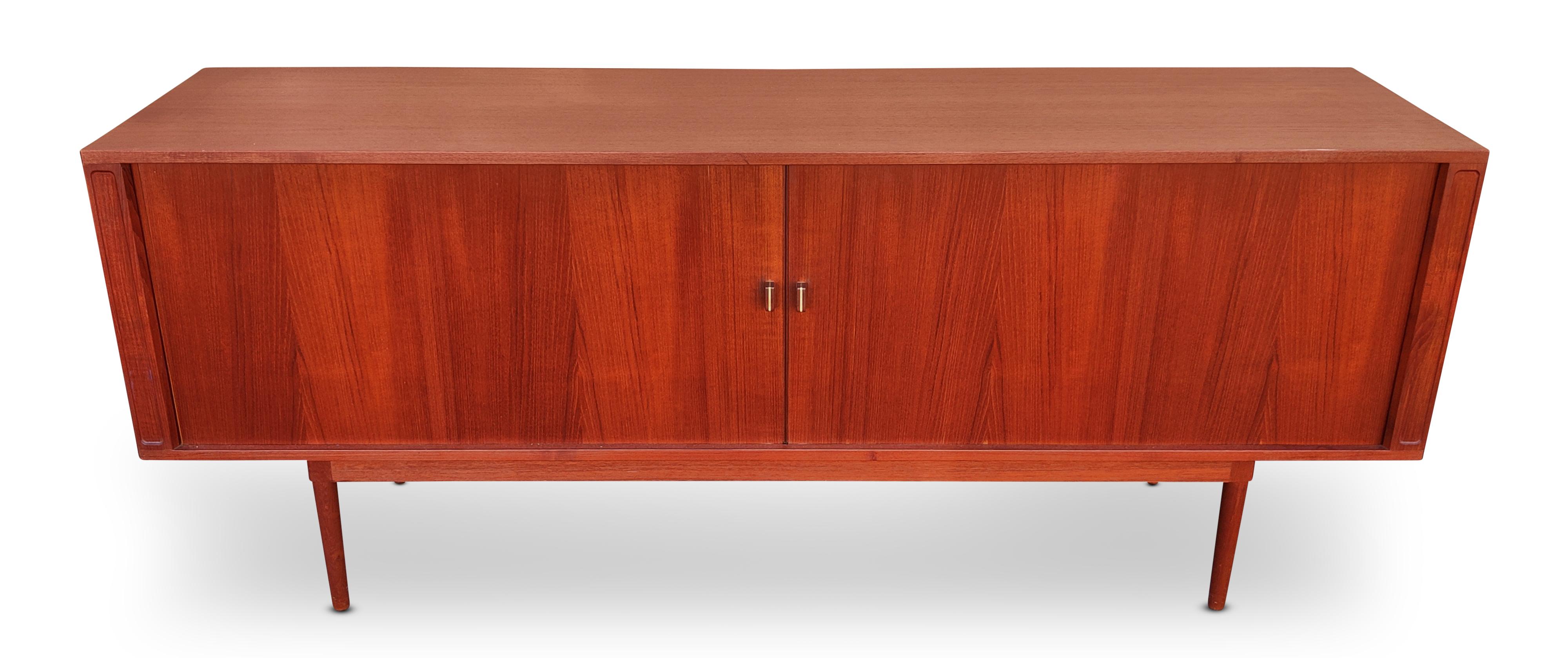 Elegant credenza designed and manufactured by Peter Løvig Nielsen in Denmark, dated 1965. Featuring a teak wood construction with seamless tambour doors adorned with subtle aluminum-accented pulls. The doors open smoothly to reveal ample storage
