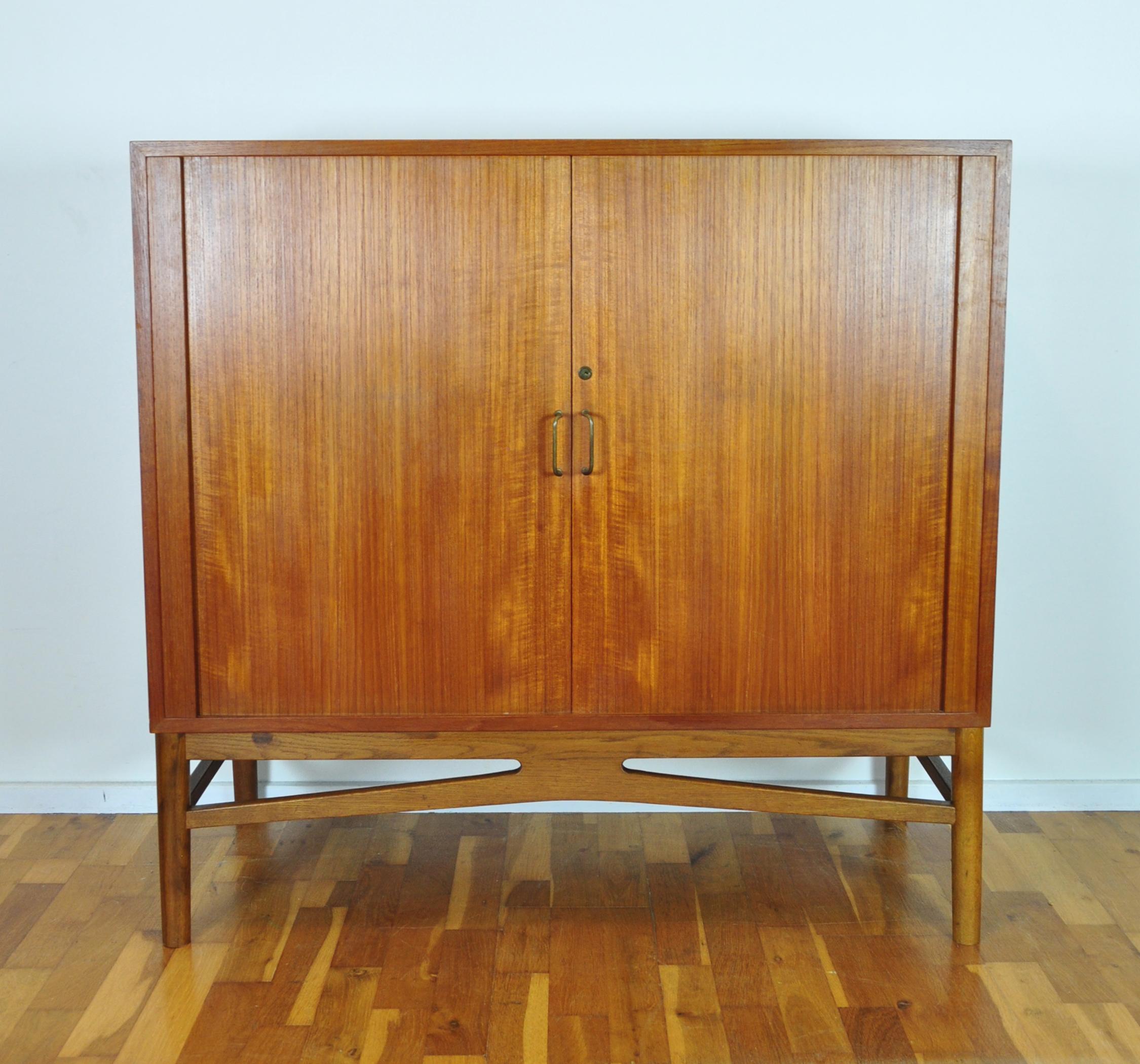 Danish modern teak tambour file cabinet.
Front doors with handles in brass and 8 drawers. Drawers with fine cabinet maker details. Good craftsmanship.