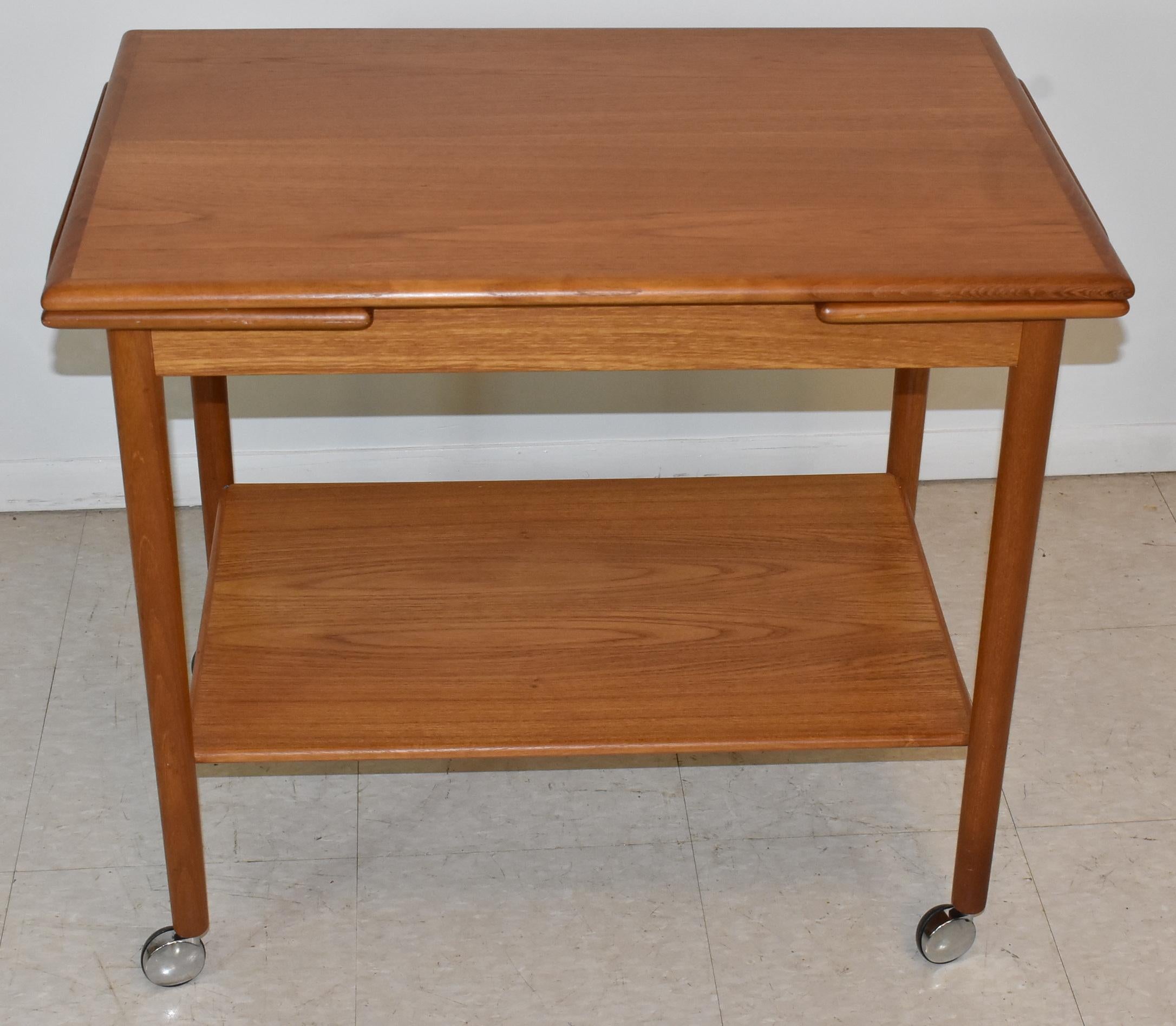 Danish modern teak bar / tea cart by Dyrlund. Two leaf pullouts and rolling chrome wheels. Very good to excellent condition. Dimensions: 19