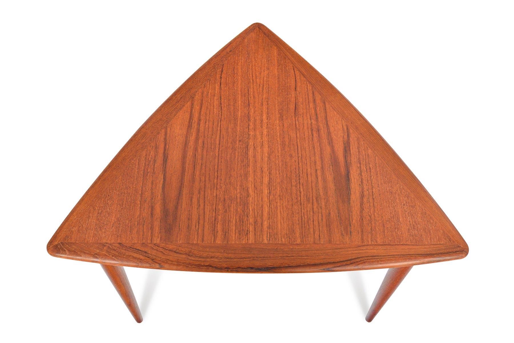 This beautifully crafted Danish modern side table is designed with striking triangle silhouette. Three spindle legs support a teak framed, caned rack. In excellent original condition.

  