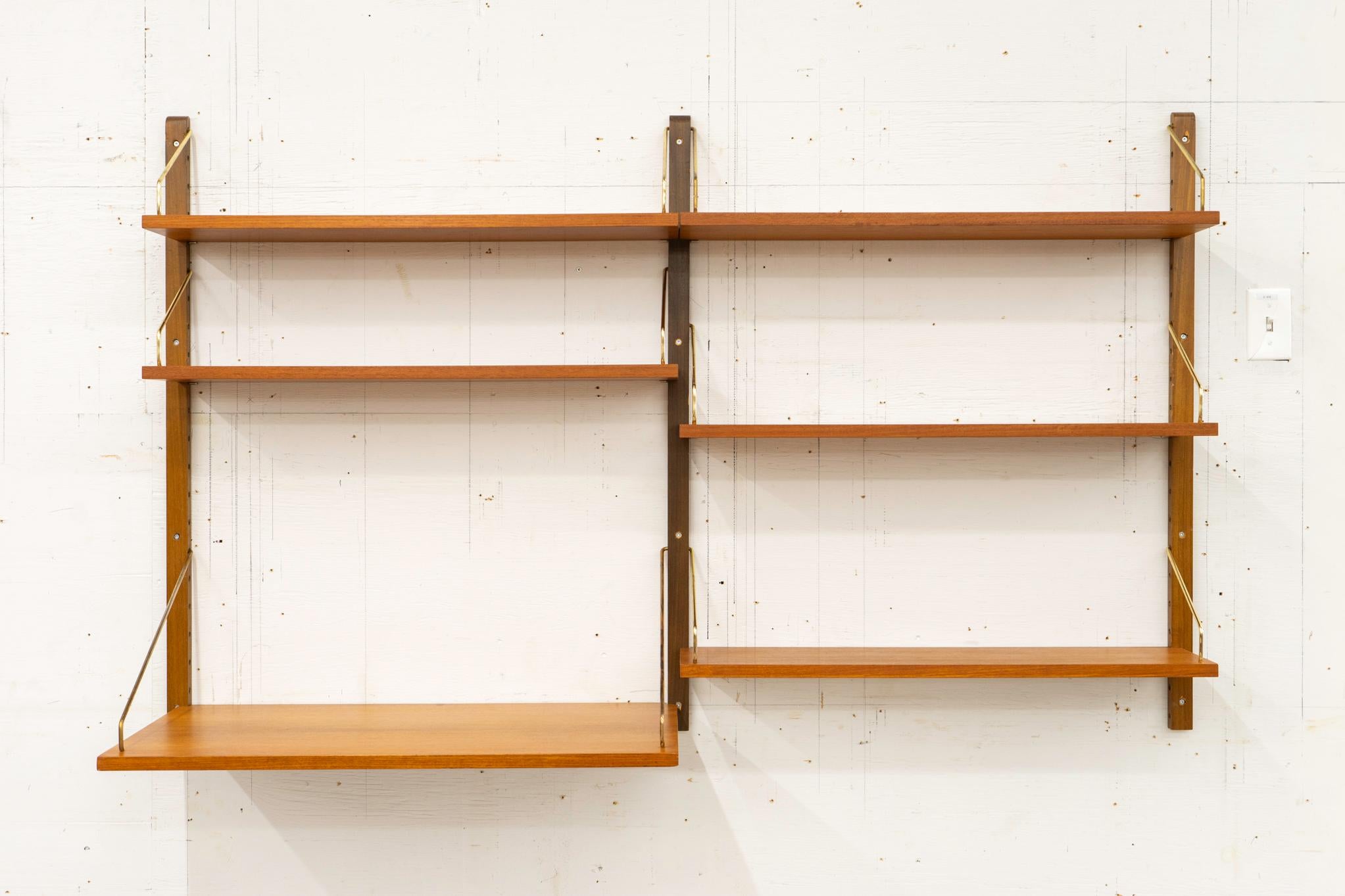 Dänisches Wandsystem aus Teakholz, ca. 1960er Jahre. Doppelter Bankschrank aus Teakholzfurnier mit modularen Regalen. Enthält: 3 Schienen, 1 x 16 