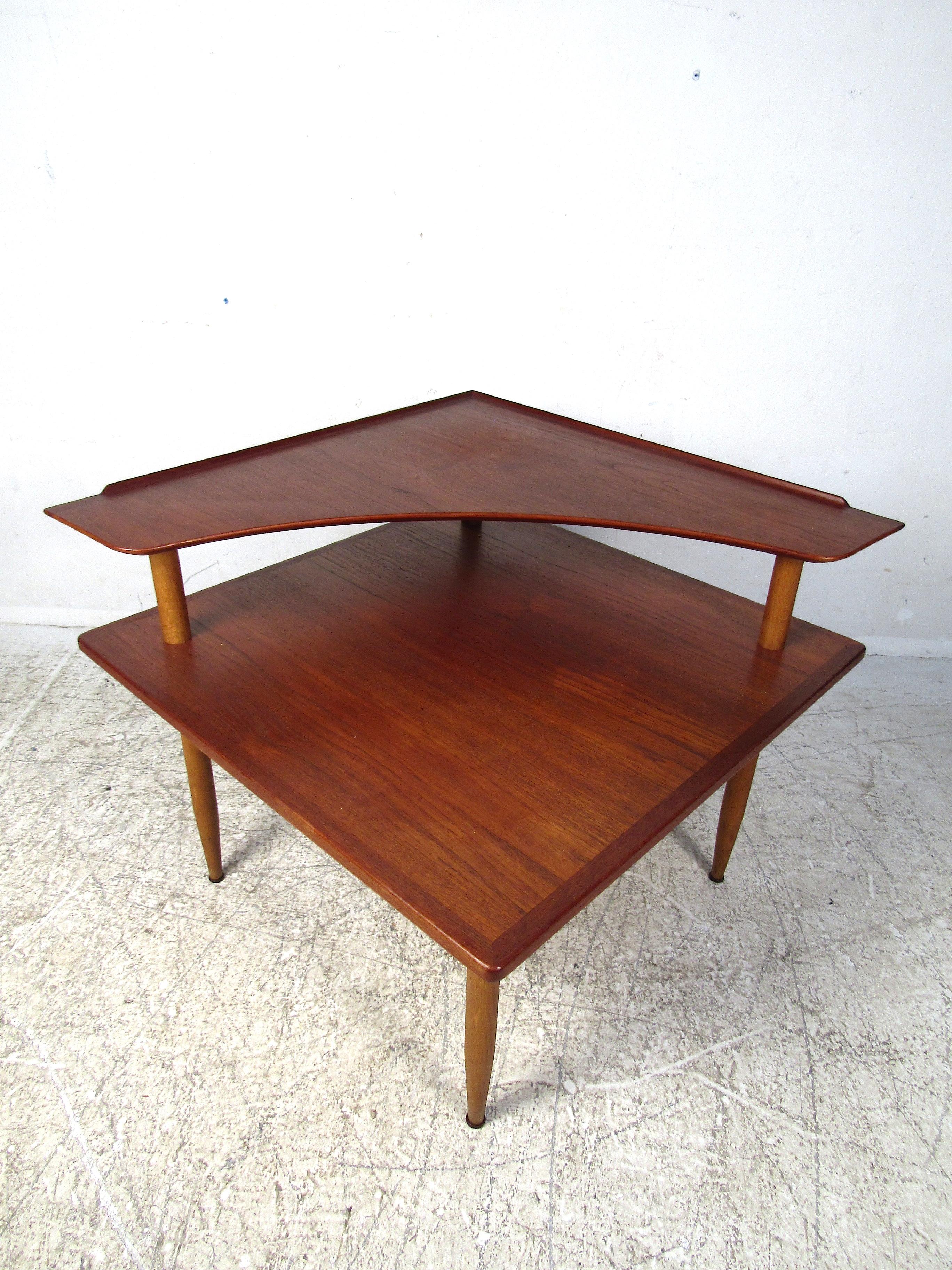 Very nice midcentury/Danish modern coffee table with two tiers. Upper-tier has a routed lip as well as a curved edge giving this table a very unique look. Table is supported by tapered legs with stretchers running across. This table is sure to be a