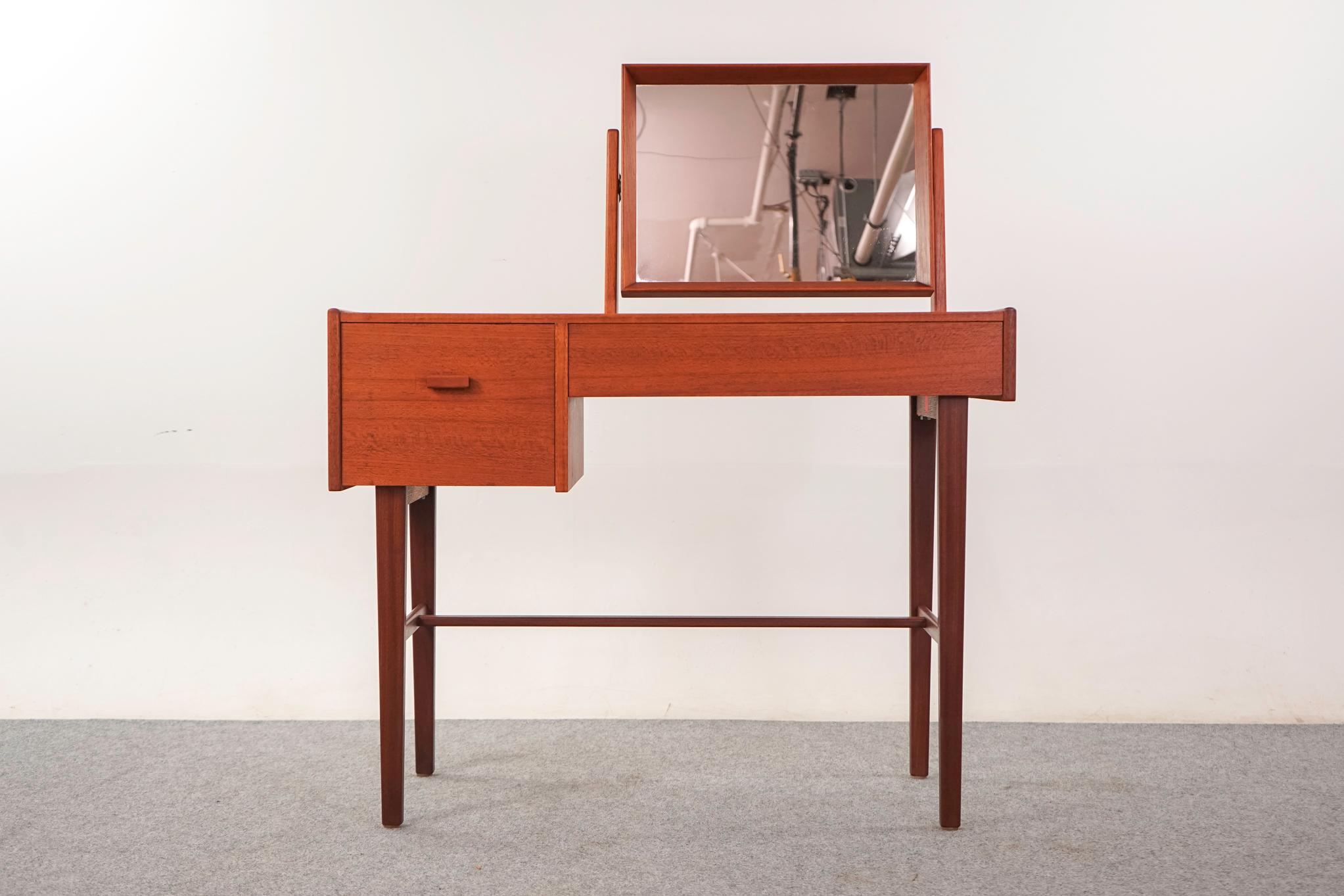 Vanità moderna danese in teak, anni '60 circa. Rifiniture massicce e splendida impiallacciatura in tinta con il libro. Cassetti a coda di rondine, gambe eleganti e specchio girevole originale in buone condizioni. 

Un articolo non restaurato con la