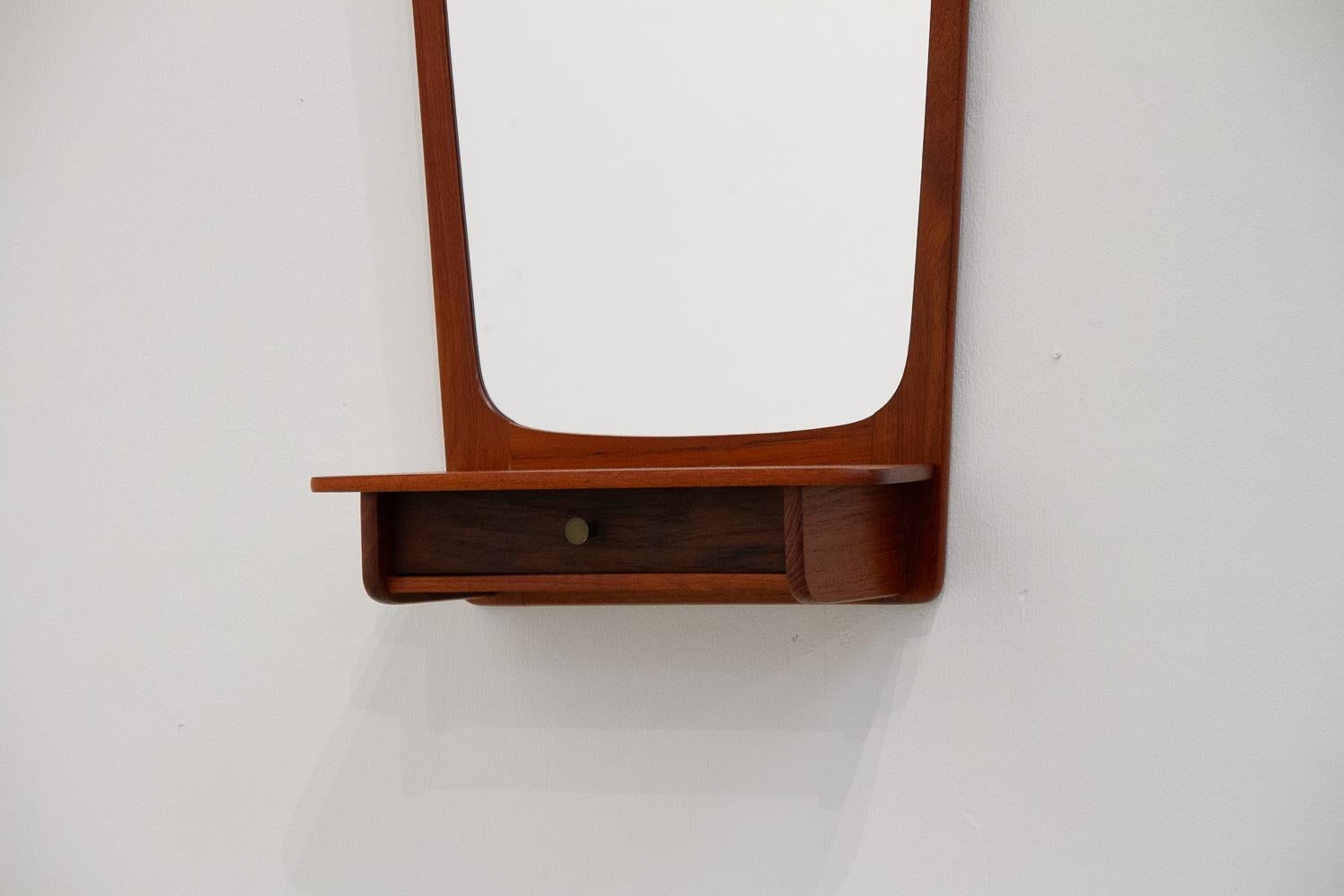 Danish Modern Teak Wall Mirror with Drawer, 1960s.
Classic and elegant Scandinavian Mid-Century Modern wall mounted mirror with shelf and small drawer. Drawer pull in solid brass.

Very good original condition with only light patina consistent with