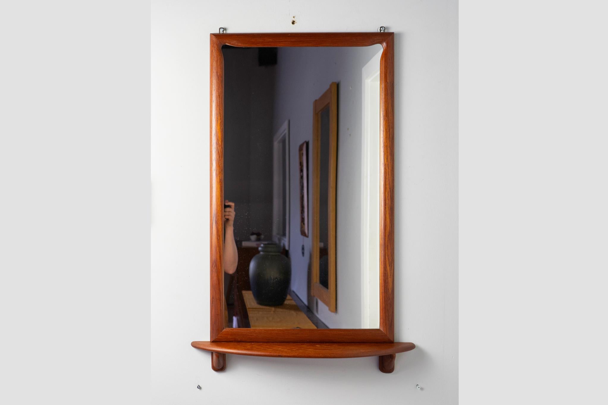 Dänischer Spiegel aus Teakholz, ca. 1960er Jahre. Charmanter Spiegel mit geschwungener Ablage, einzigartigen Eckdetails und schönen Maserungen. Originalglas mit leichten Gebrauchsspuren. Hängen Sie dies an Ihre Haustür!