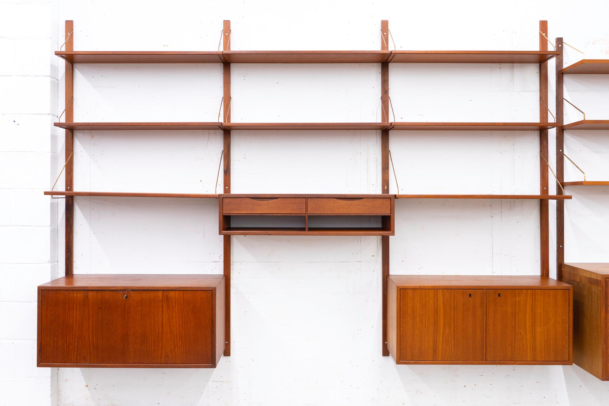 Dänisches Wandsystem aus Teakholz, ca. 1960er Jahre. Dreifach-Bank-Wandsystem mit Massivholzverkleidung, beeindruckenden, buchähnlichen Furnieroberflächen und Messingarmaturen. Modulares Design: Hängen Sie es einfach in jeder beliebigen