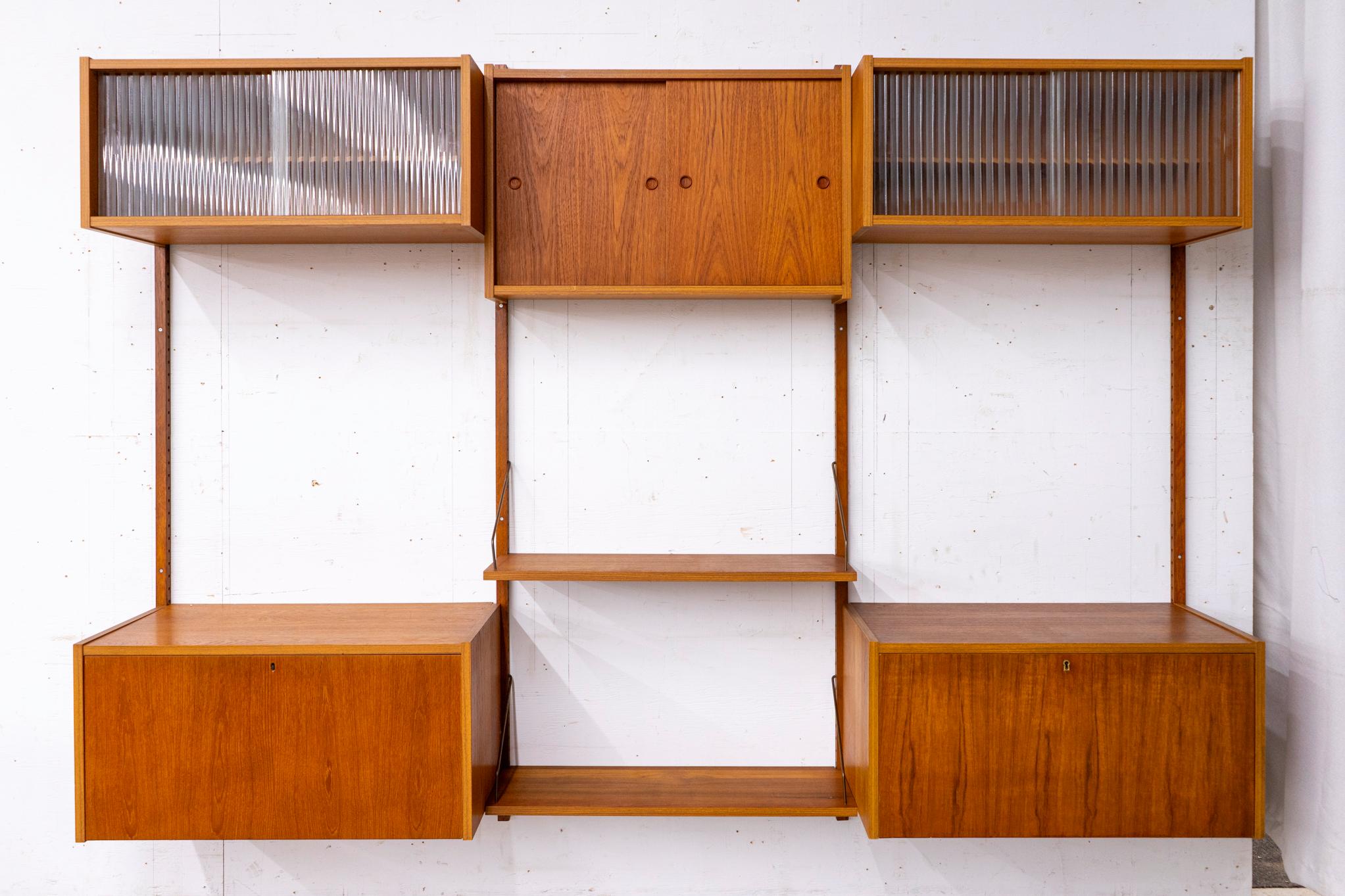Teak Danish wall system, circa 1960s. Solid wood trim with stunning book-matched veneer. Modular components, hang it any configuration you wish! Works nicely as 2 single bank systemens too! Includes: 4 rails, 2 drop-down cabinets, 2 shelves, 2 glass