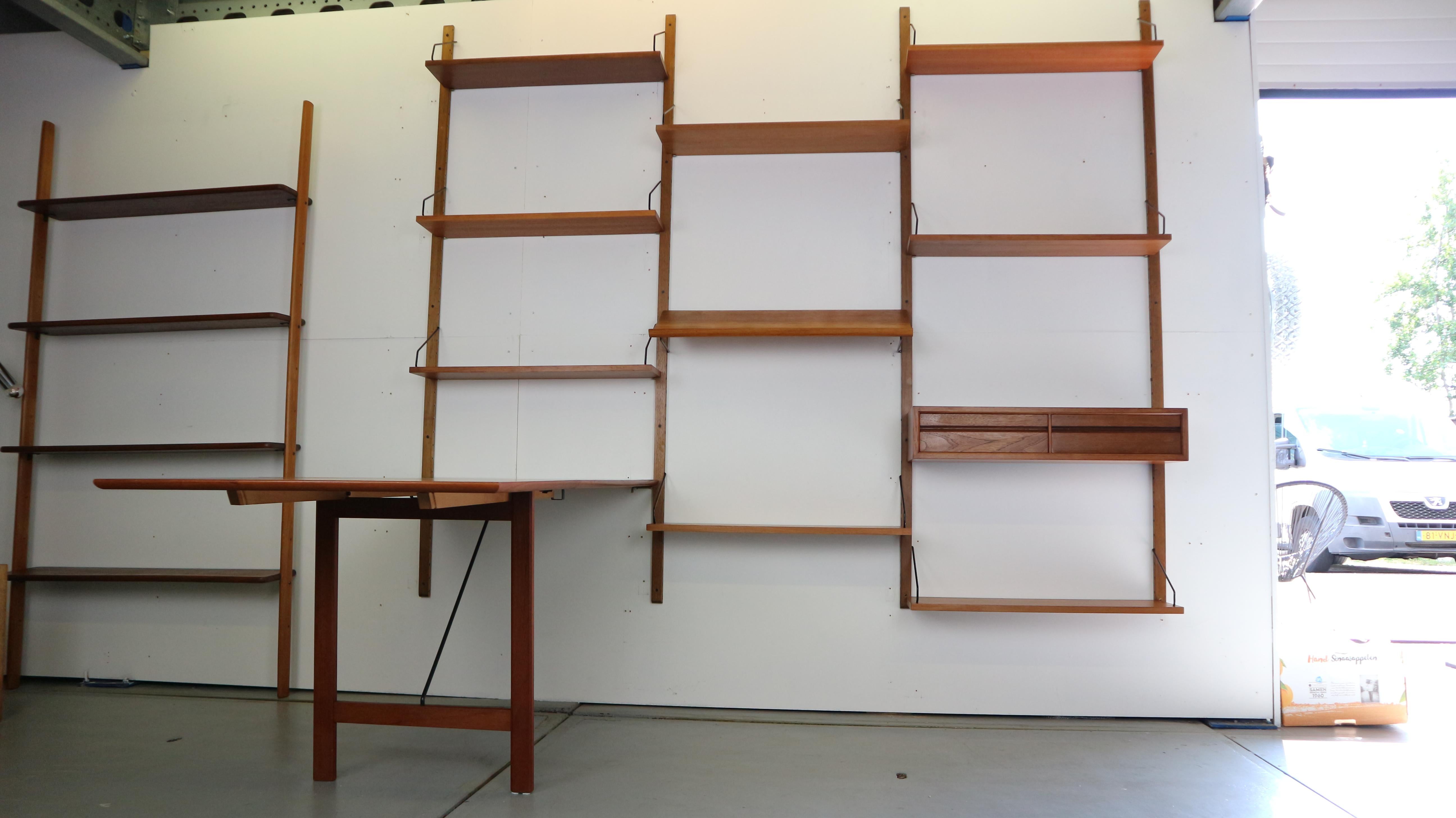 Danish modern teak wall unit or home office, designed by Poul Cadovius for Cado, Denmark, circa 1960s. This piece is completely adjustable, and any of the case pieces or shelves can be installed anywhere up and down the wall-mounted uprights.
This