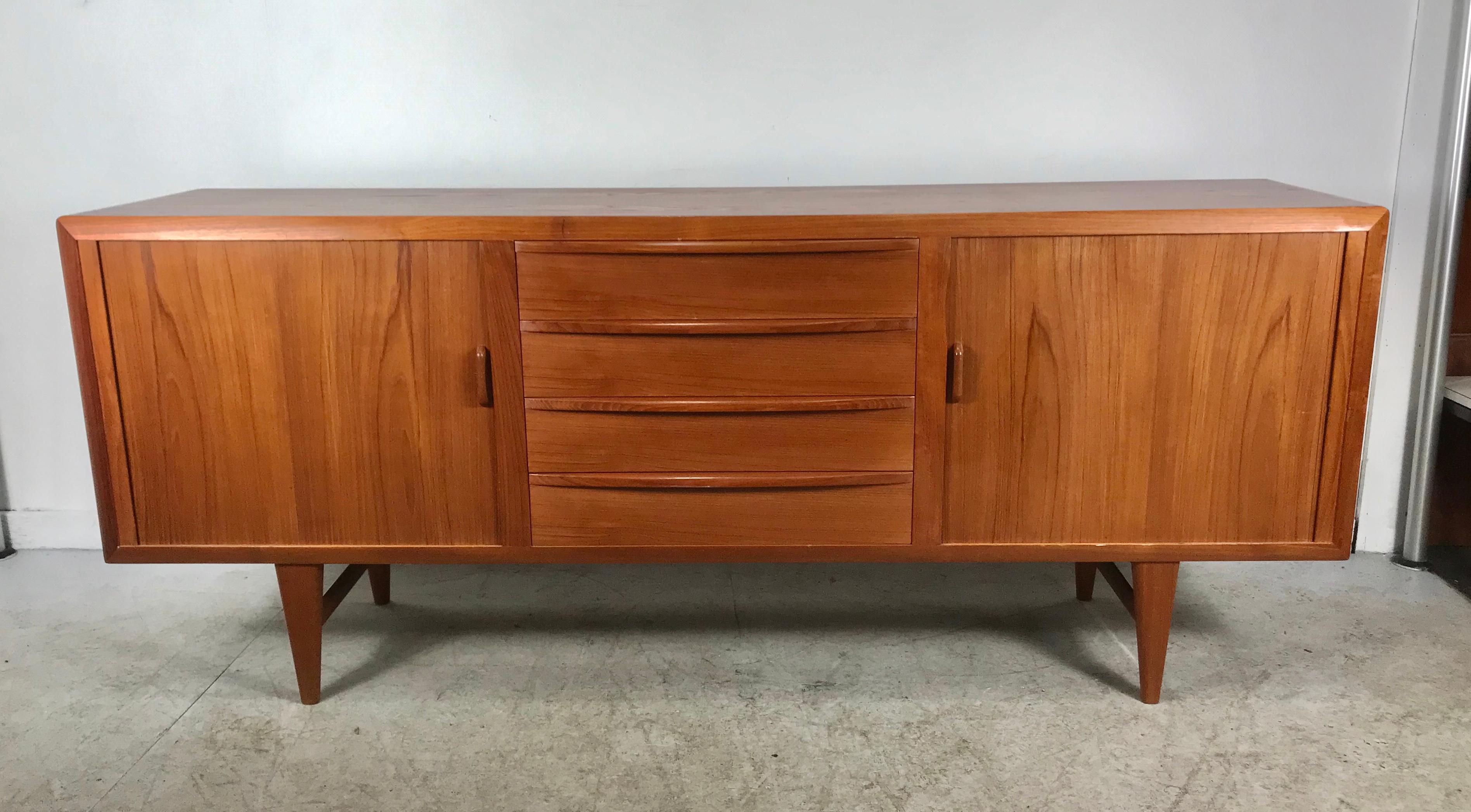 Magnificent and rare Danish design sideboard designed by: Ib Kofod-Larsen for the Faarup Møbelfabrik in the 1950s. An exceptional beautiful sideboard with organic lines and warm teak wood. The sideboard has four drawers and two tambour doors who