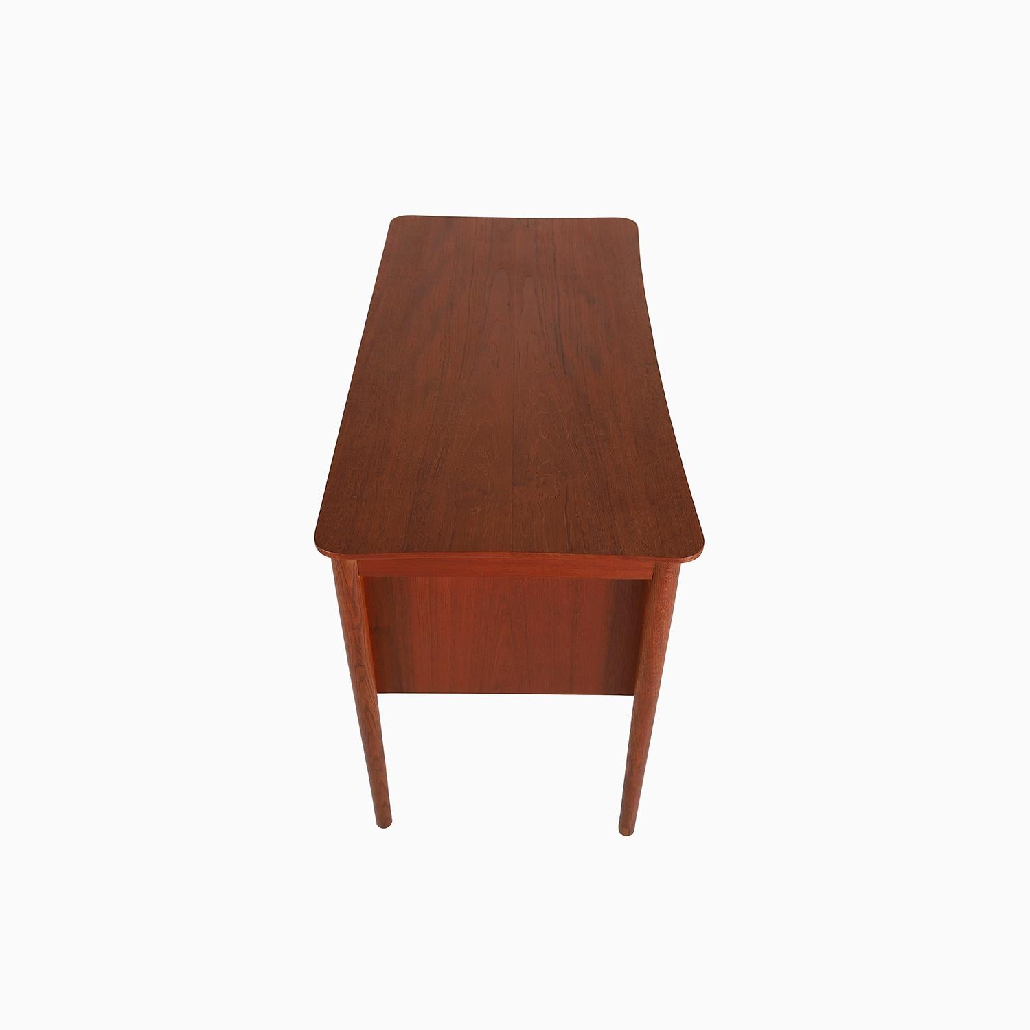 This delicate yet modern teak desk is made from rich old growth teak and has an absolutely lovely patina.  A left sided drawer bank with sculptural finger pulls and a locking key.   Curved aprons and gently curved desktop make this piece a bit