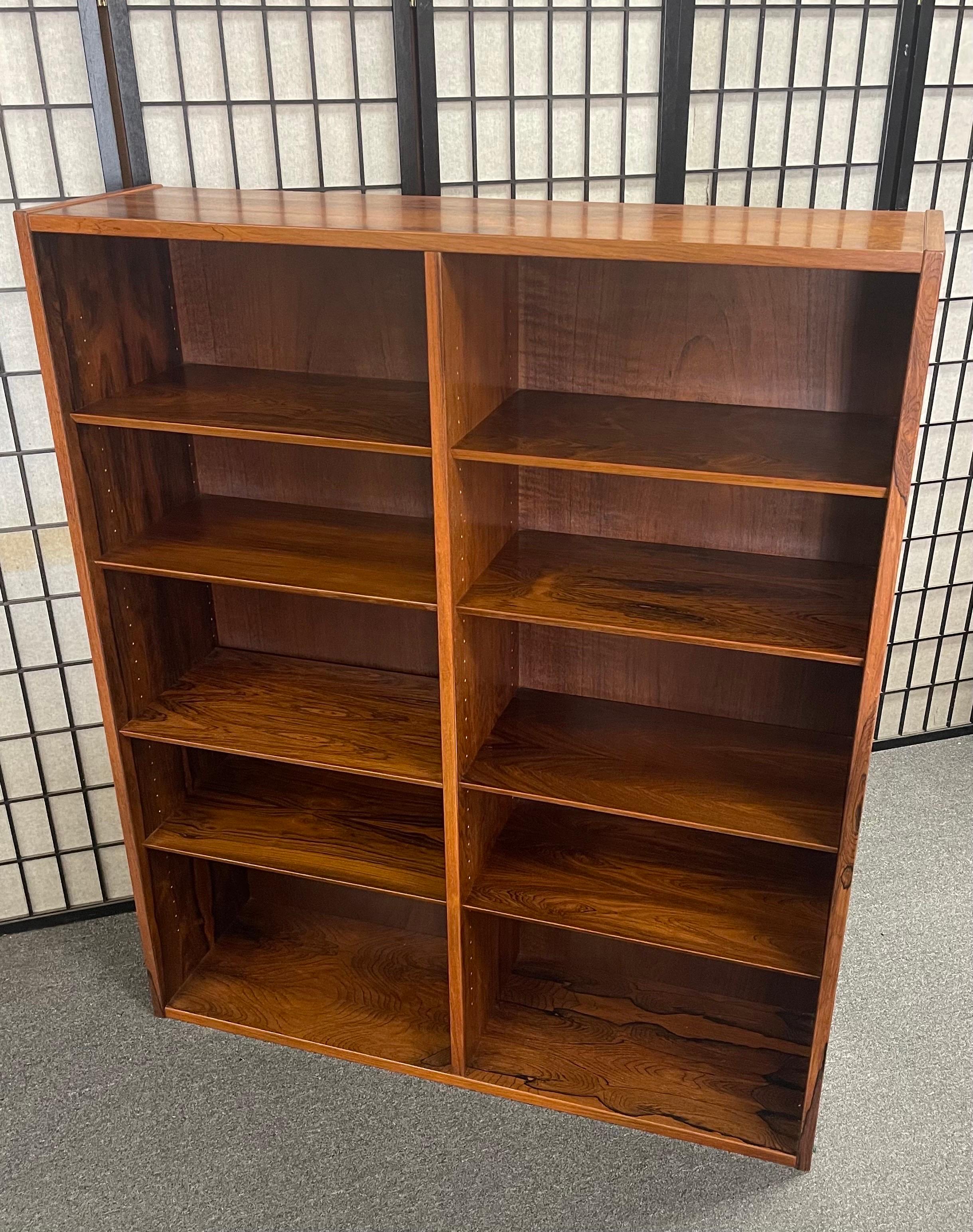 Beautiful and elegant Danish modern ten shelf rosewood bookcase in the style of Poul Hundevad, circa 1960's. The bookcase is in very good vintage condition, has a gorgeous rosewood grain and beveled edged adjustable shelves. The piece measures