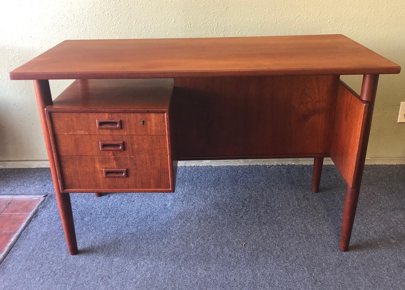 This Danish modern floating top desk features a beautifully cornered teak slab desk space. One bank of three dovetailed drawers sit on the left side of the knee hole providing excellent storage. Finished on all sides, this desk can be floated in the