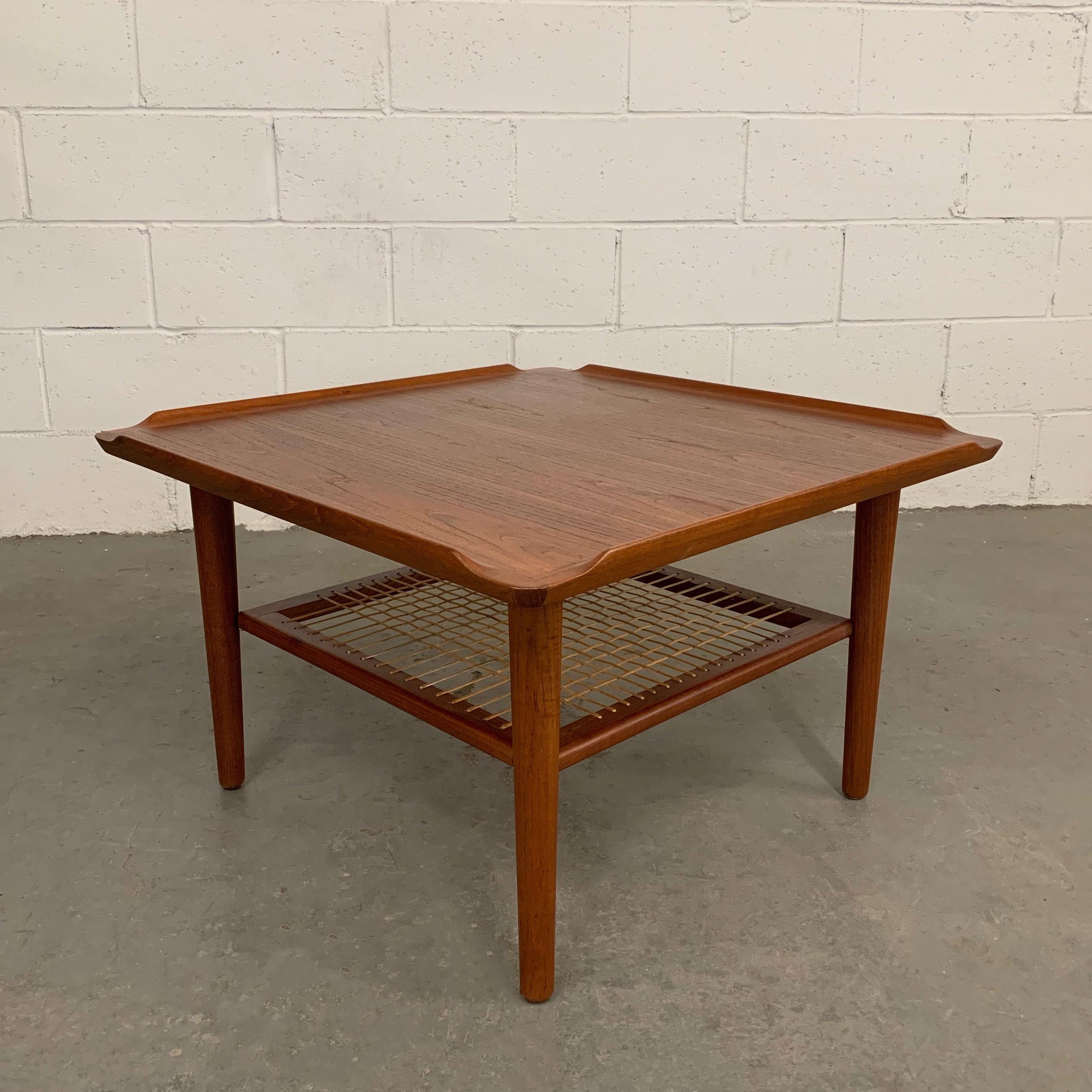 Danish modern, teak coffee or side table features an upturned top surface and a lower woven caned tier 20 inches below is attributed to George Jensen.