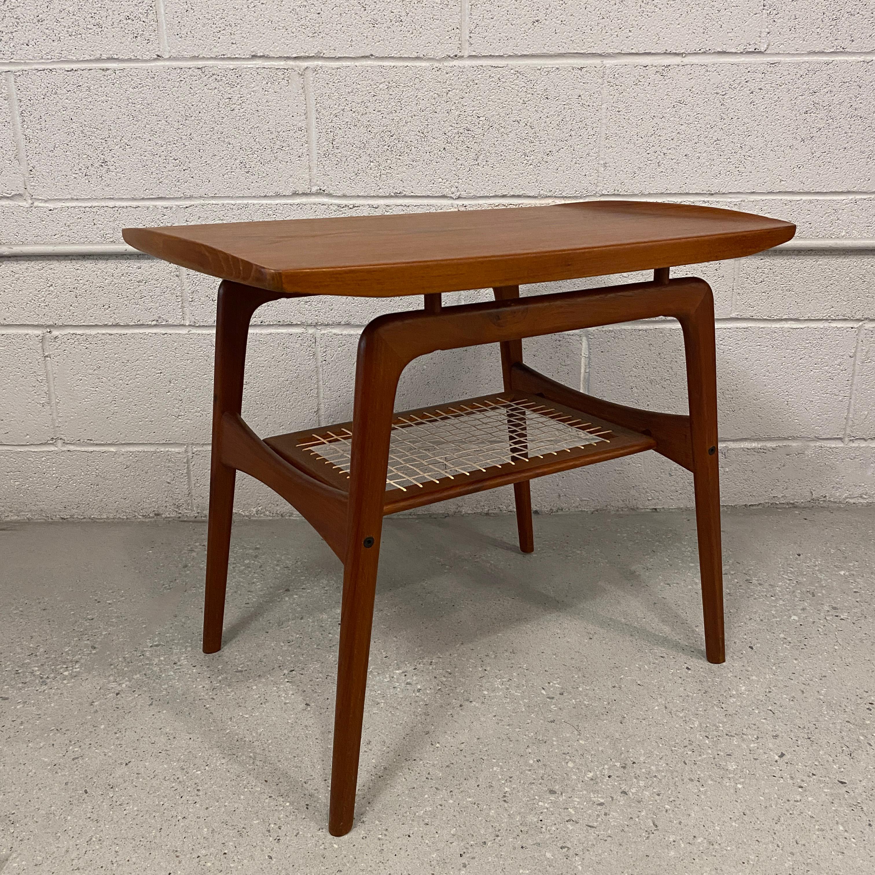 Danish modern, tiered teak side table by Arne Hovmand-Olsen features a floating top with upturned edges and lower, caned tier at 11.5 inches height.
