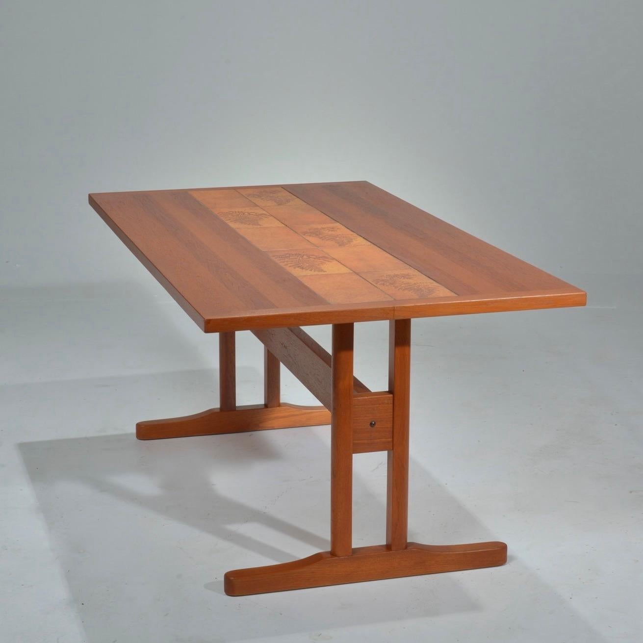 Il s'agit d'une belle table de bureau ou de table à manger en teck incrusté de carreaux. Elle est en excellent état vintage.