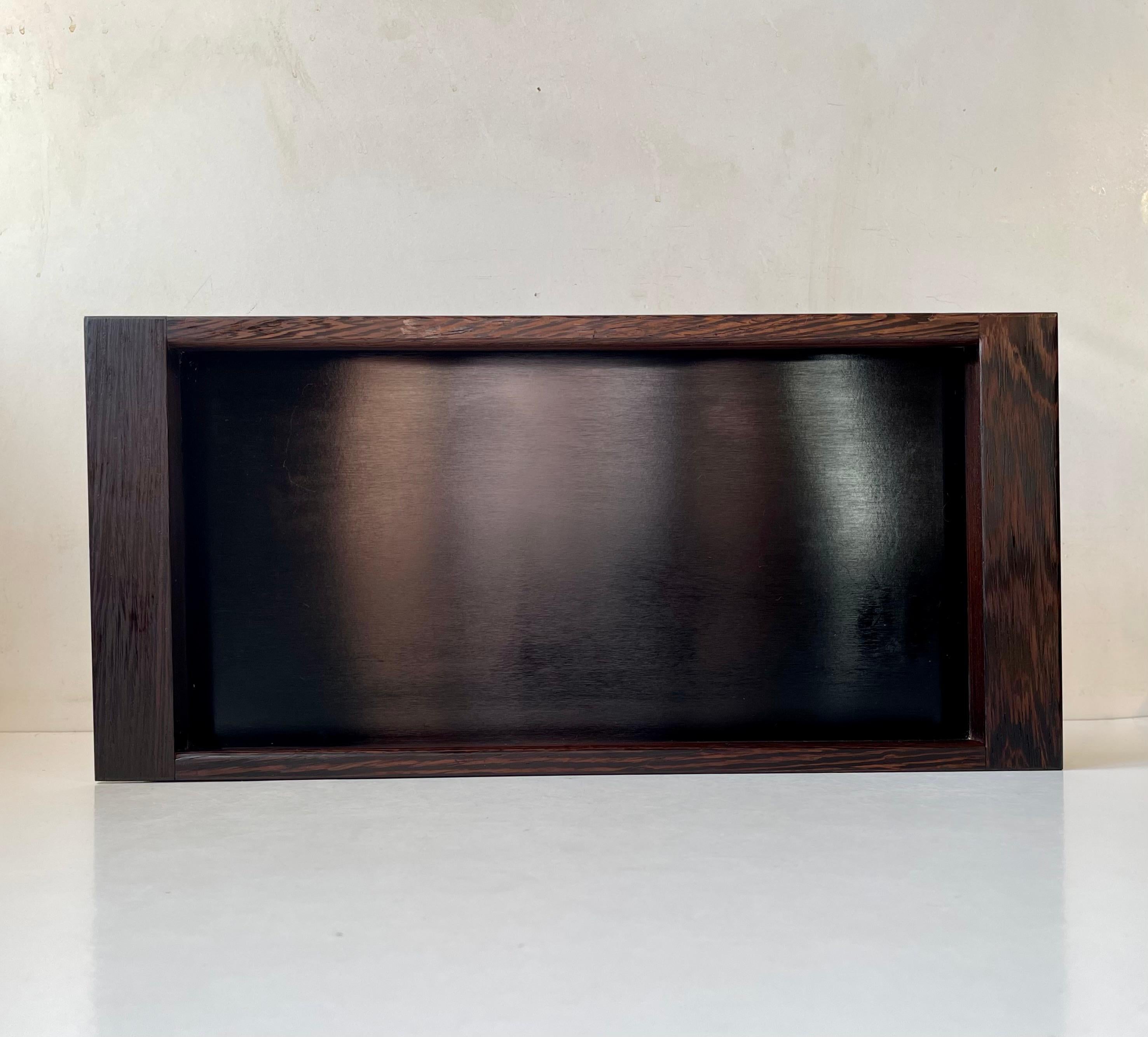 Exceptionally rare 1960s serving or decorative tray executed in Wengé wood and black formica. It was designed during the late 1950s or early 60s by Henning Seidelin. Manufactured by Voss in Denmark during the 1960s. It share some of the same