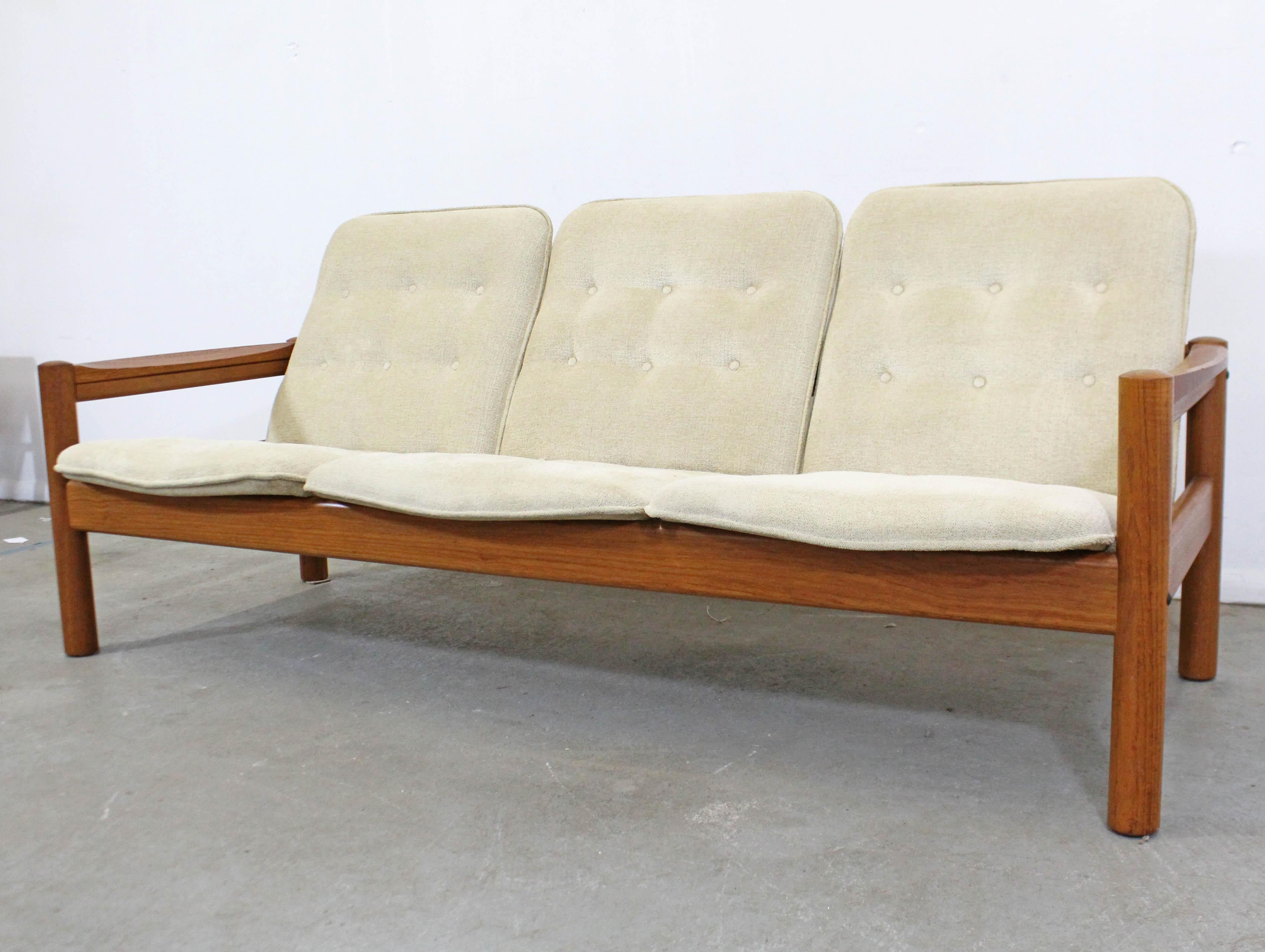 Offered is a Danish modern teak sofa made by Domino Mobler. Features original tufted upholstery and a solid teak frame. In very good vintage condition, has minor age wear, small chips on arm, and one back button is missing. It is structurally sound.