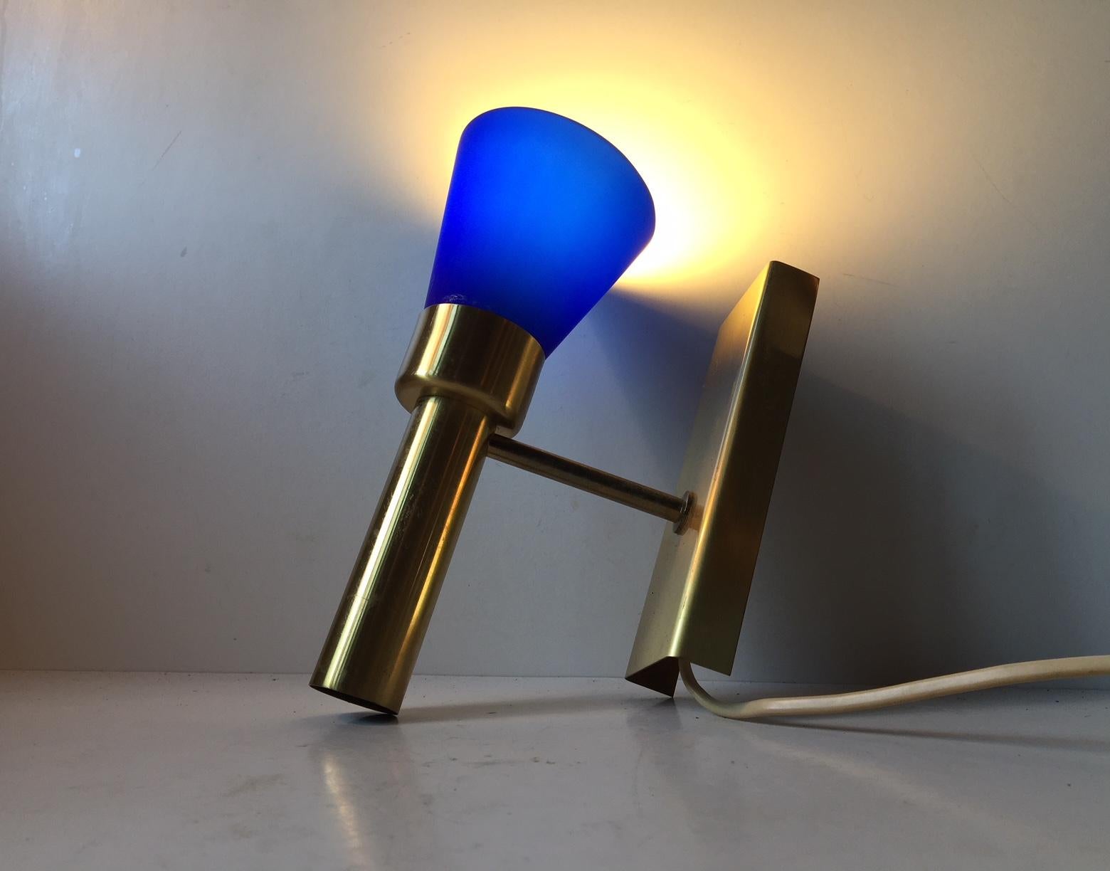 Up-light sconce produced by Vitrika in Denmark during the 1960s. It is called Bodegalampet (Design no.: 17019) and is made from brass set with a conical blue cased opaline glass shade.

For the US. It will come installed with a 110 watt adaptor plug