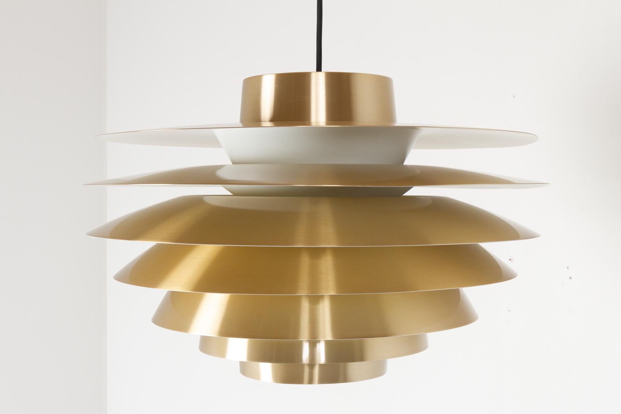 Vintage Danish Verona ceiling pendant by Svend Middelboe for Nordisk Solar, 1970s
Danish mid-century modern brass colored aluminium ceiling lamp designed by Danish lighting designer Svend Middelboe.
Seven shades disperses the light evenly without