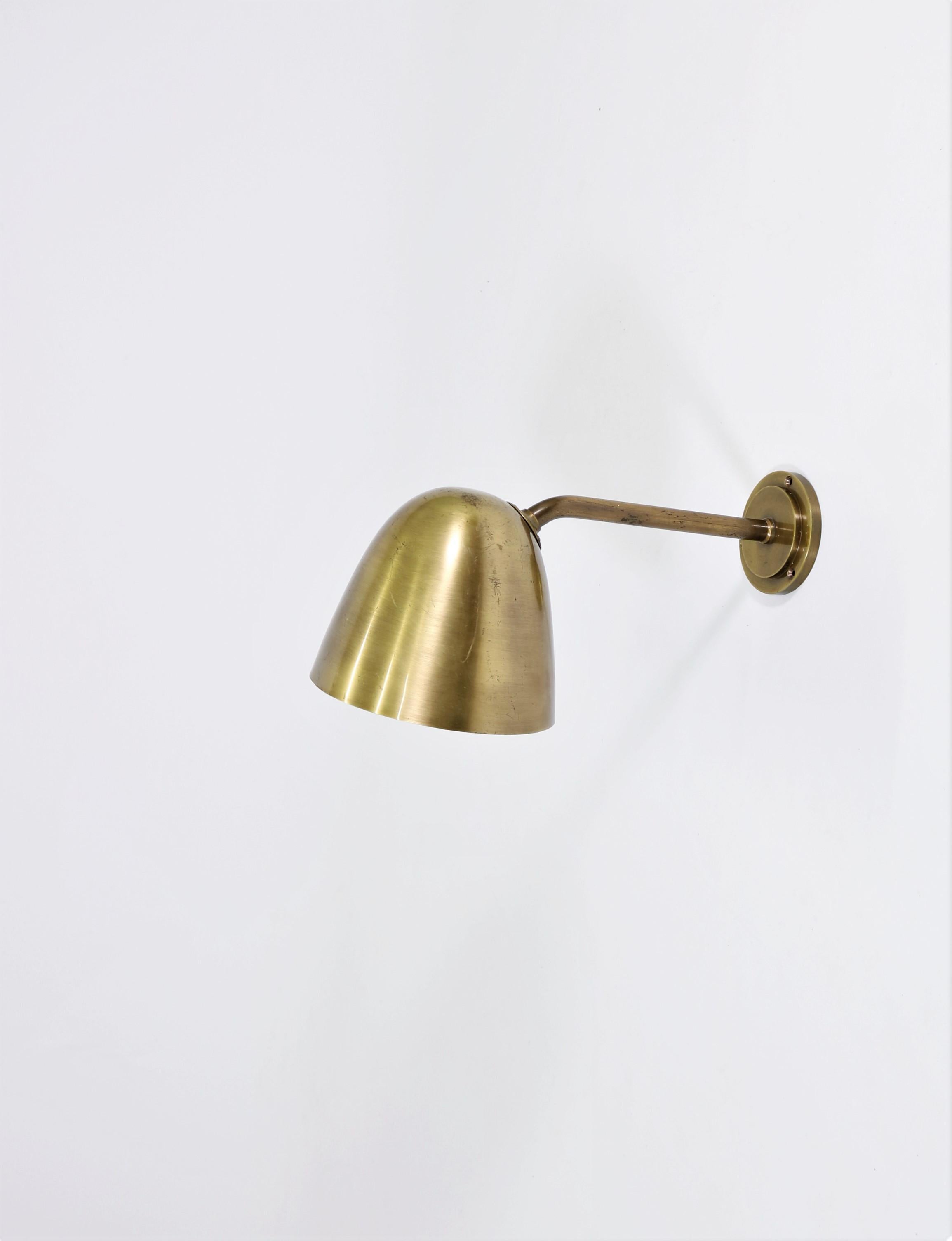 Scandinavian modern wall lamp attributed to Danish architect Vilhelm Lauritzen and manufactured by Fog & Morup, Copenhagen in the 1940s. The fixture is made from solid brass with a beautiful patina.