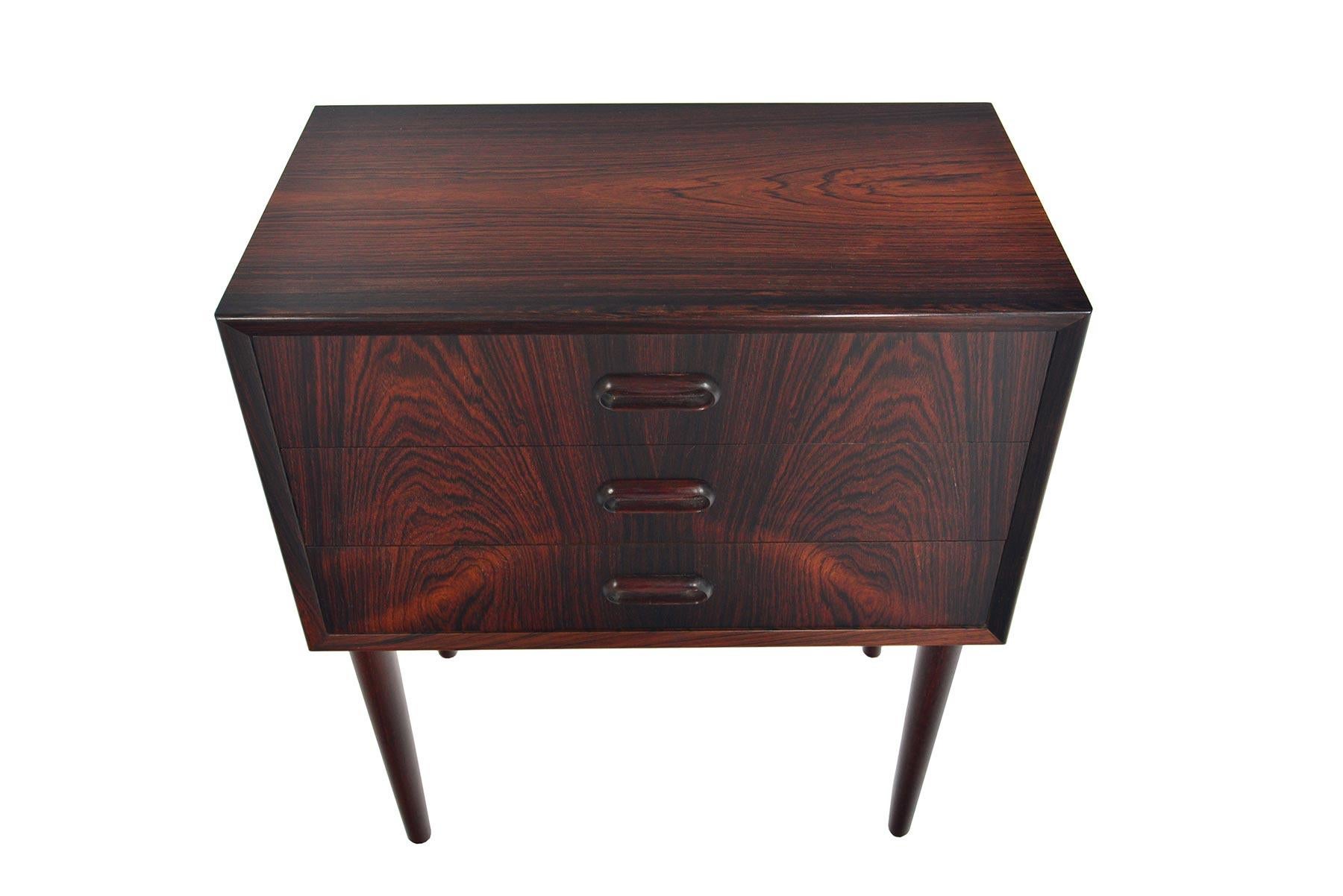 This Danish modern midcentury three-drawer chest in Brazilian rosewood features beautiful grain patterns throughout. Perfect for use in an entry way or as a single nightstand, this piece offers exceptional storage! In excellent original condition