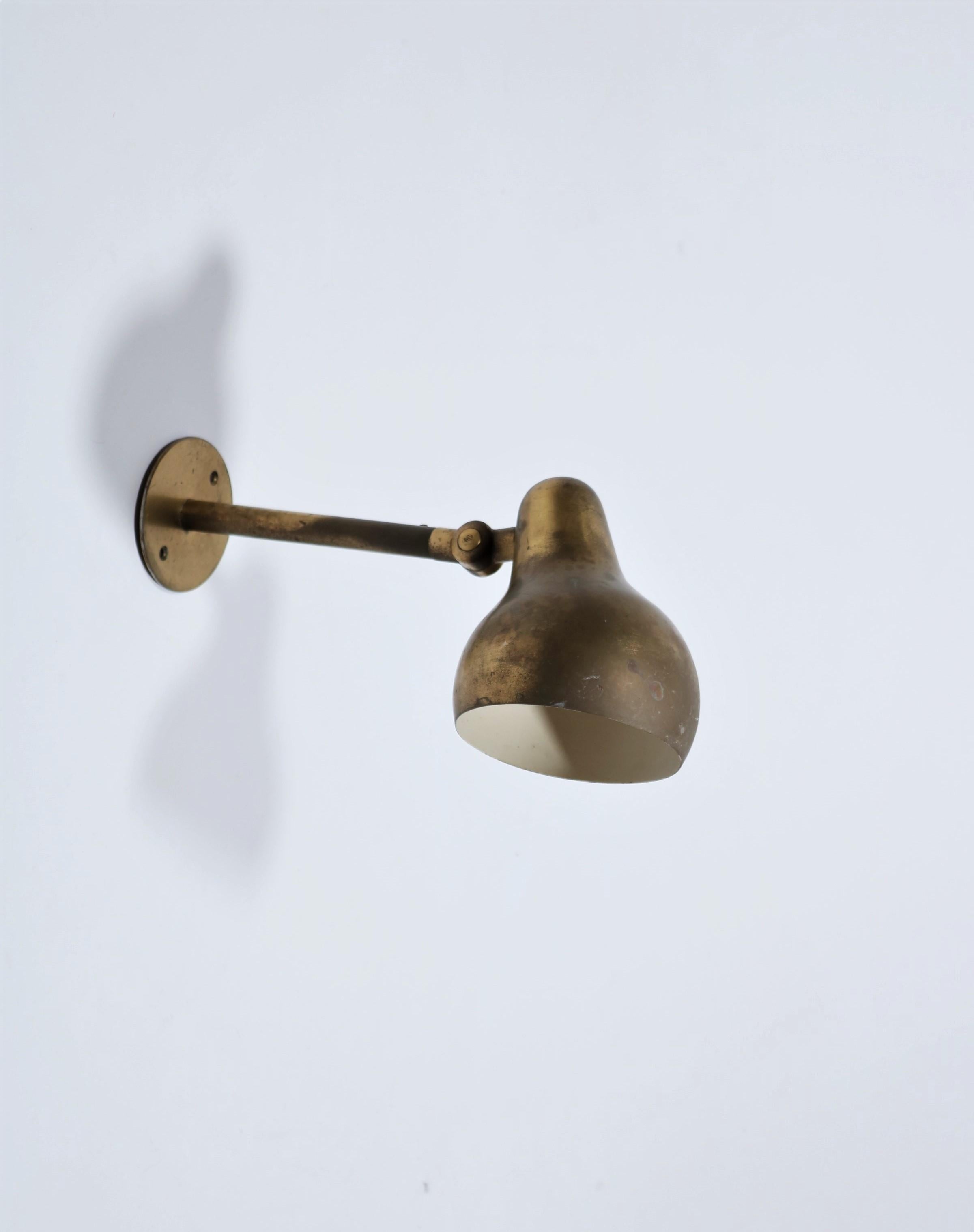 Beautiful and rare 1940s wall lamp in patinated brass by Vilhelm Lauritzen. The lamp shade can be adjusted. Produced by Louis Poulsen, Copenhagen. Marked with 