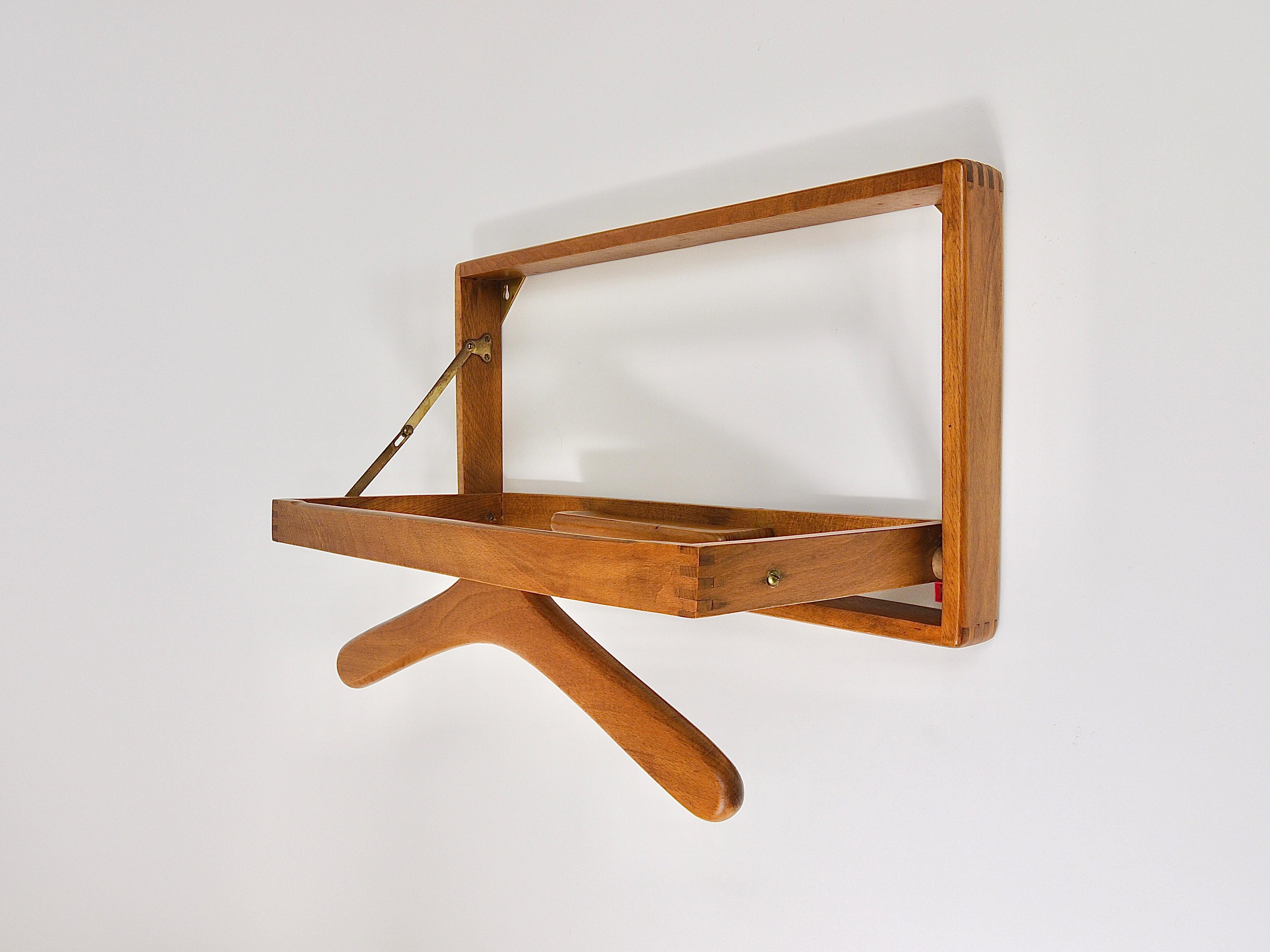 A ingenious and functional midcentury modern foldable wall valet / coat rack. Made of teak in Denmark in the 1960s. It has a folding-out hanger hold jackets, shirts, ties or pants and has also space for cufflinks, rings or a watch. In good