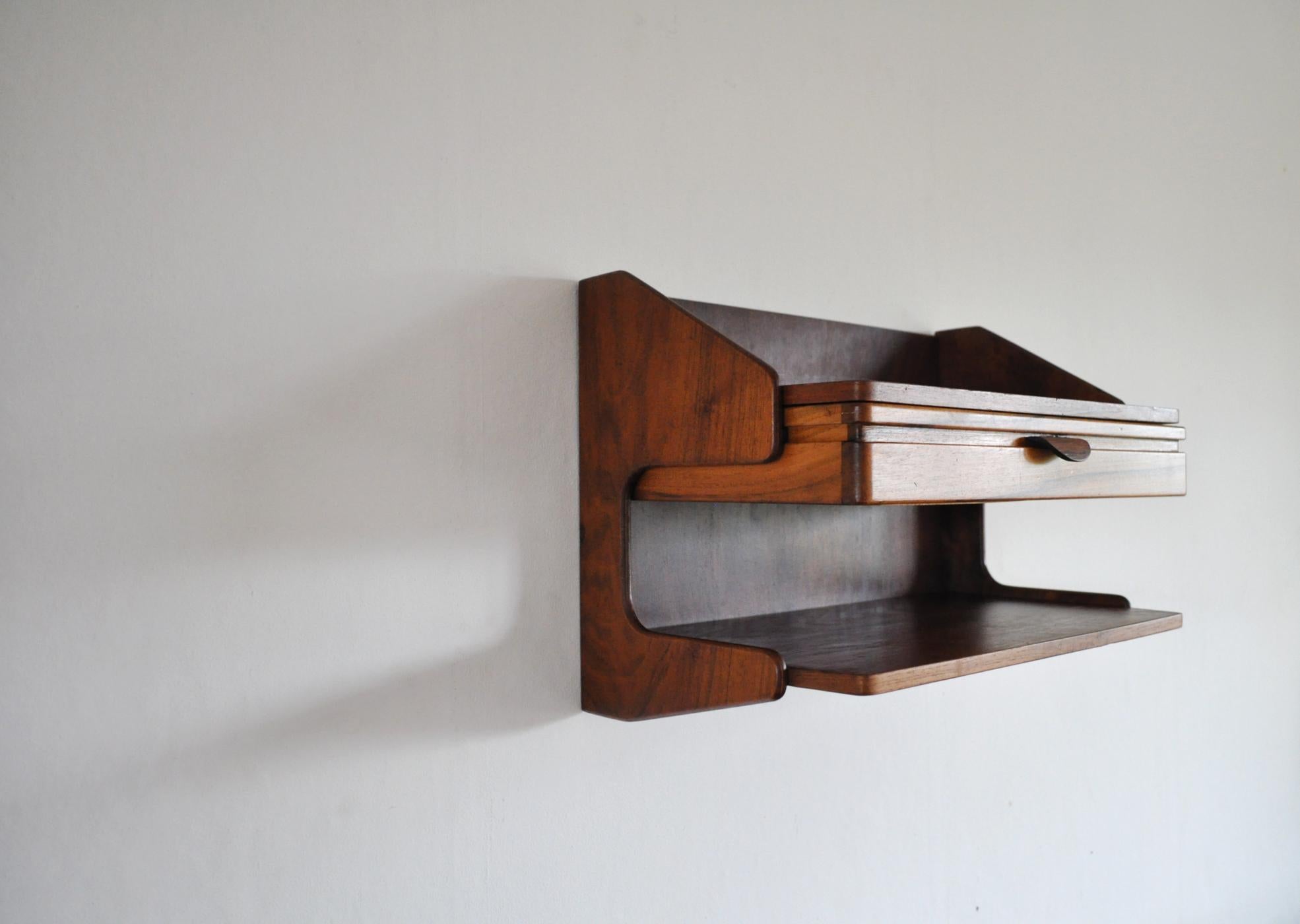 Danish modern wall-mounted storage in teak and rosewood in the style of Hans J. Wegner.
Two shelves and a drawer. 

Signs of wear consistent with age and use.

Dimensions: 
Height 32 cm
Width 46 cm 
Depth 27.5 cm.