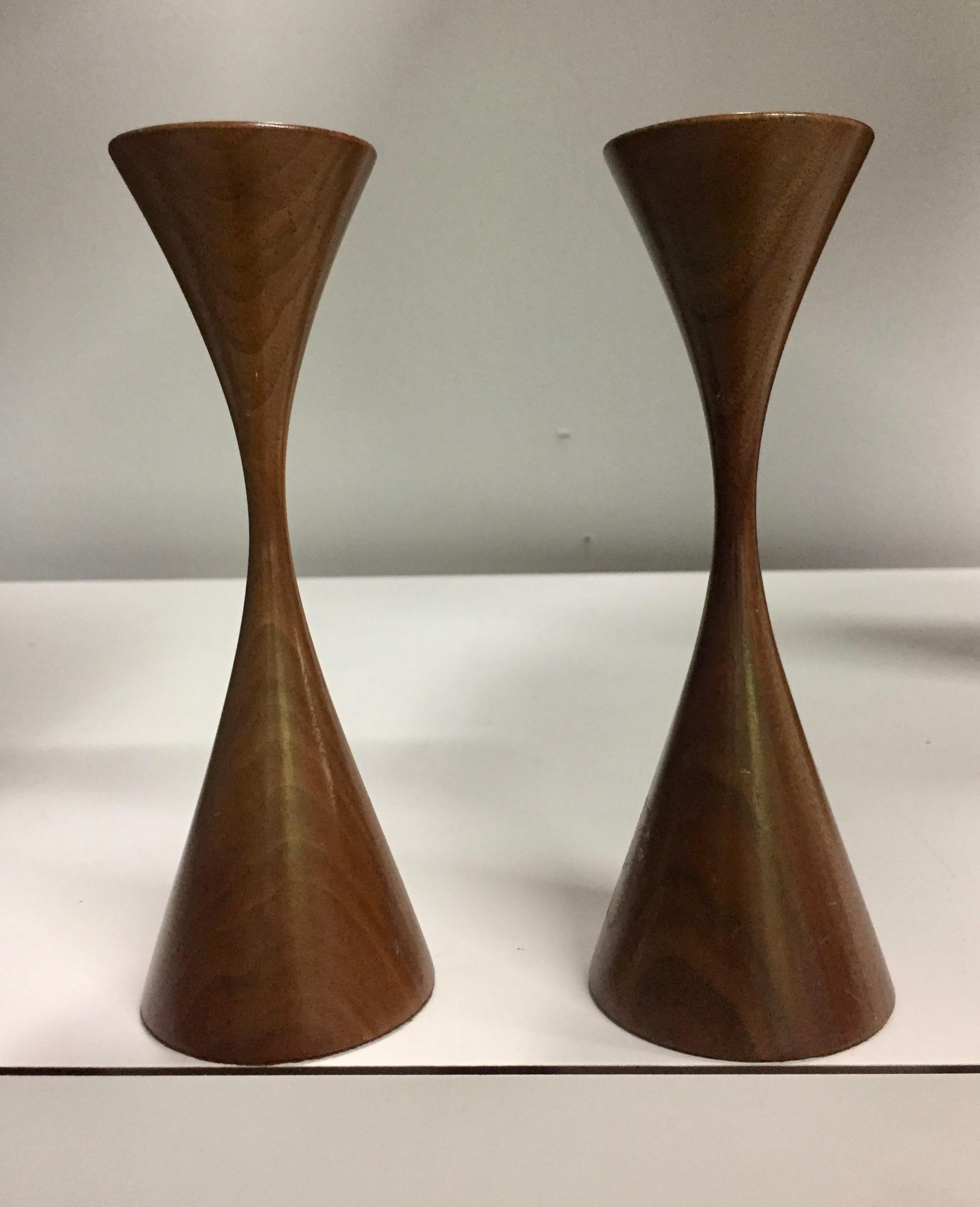 Nice pair of Rude Osolnik turned walnut candlesticks. This design is in the permanent collections of museums around the world. Their distinctive hourglass shape is instantly recognized.