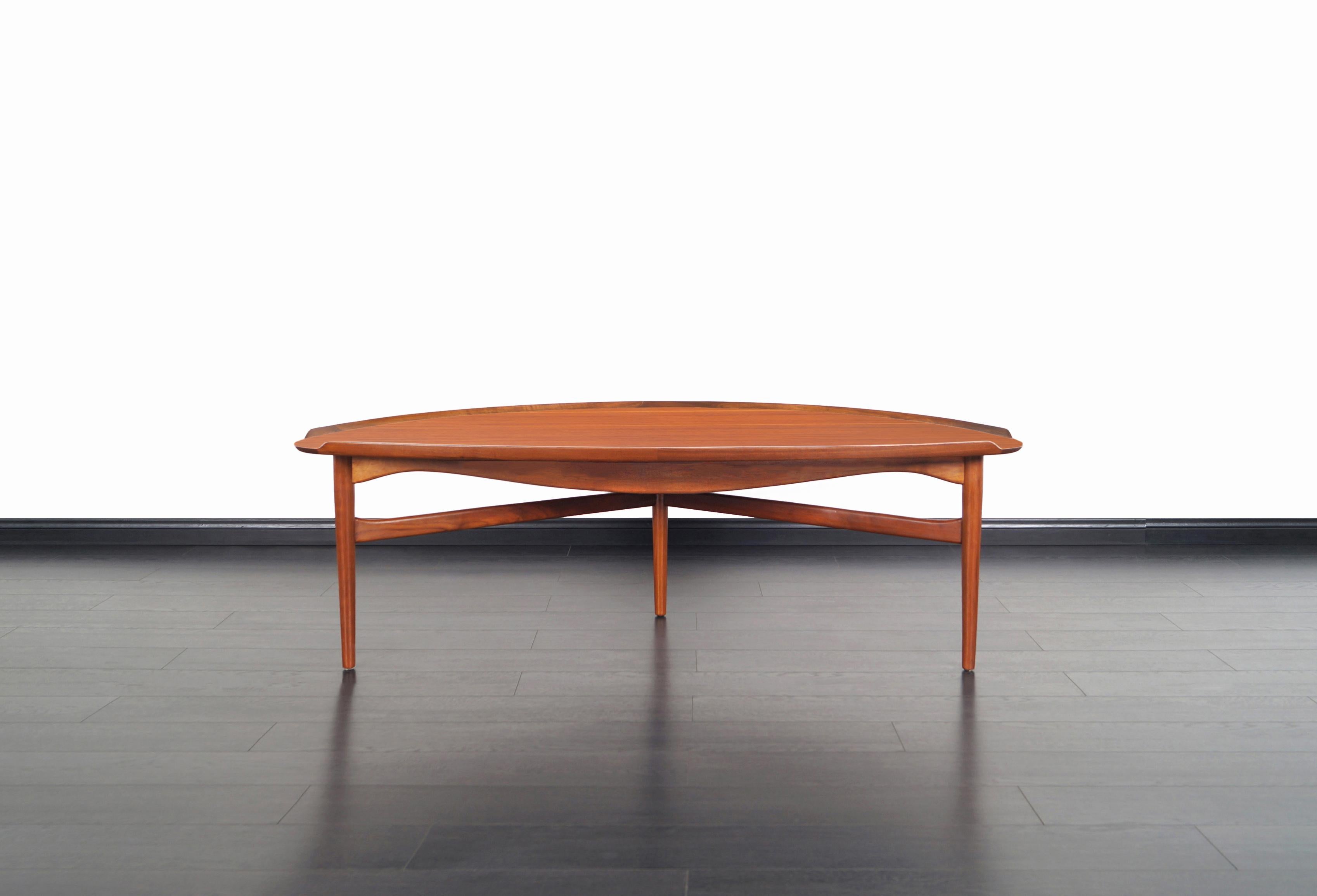 Beautiful Danish modern walnut cocktail table designed by iconic designer Finn Juhl for Baker Furniture in the United States, circa 1950s. This cocktail table has a sculptural design with no sharp corners that allow you to move freely around it. It