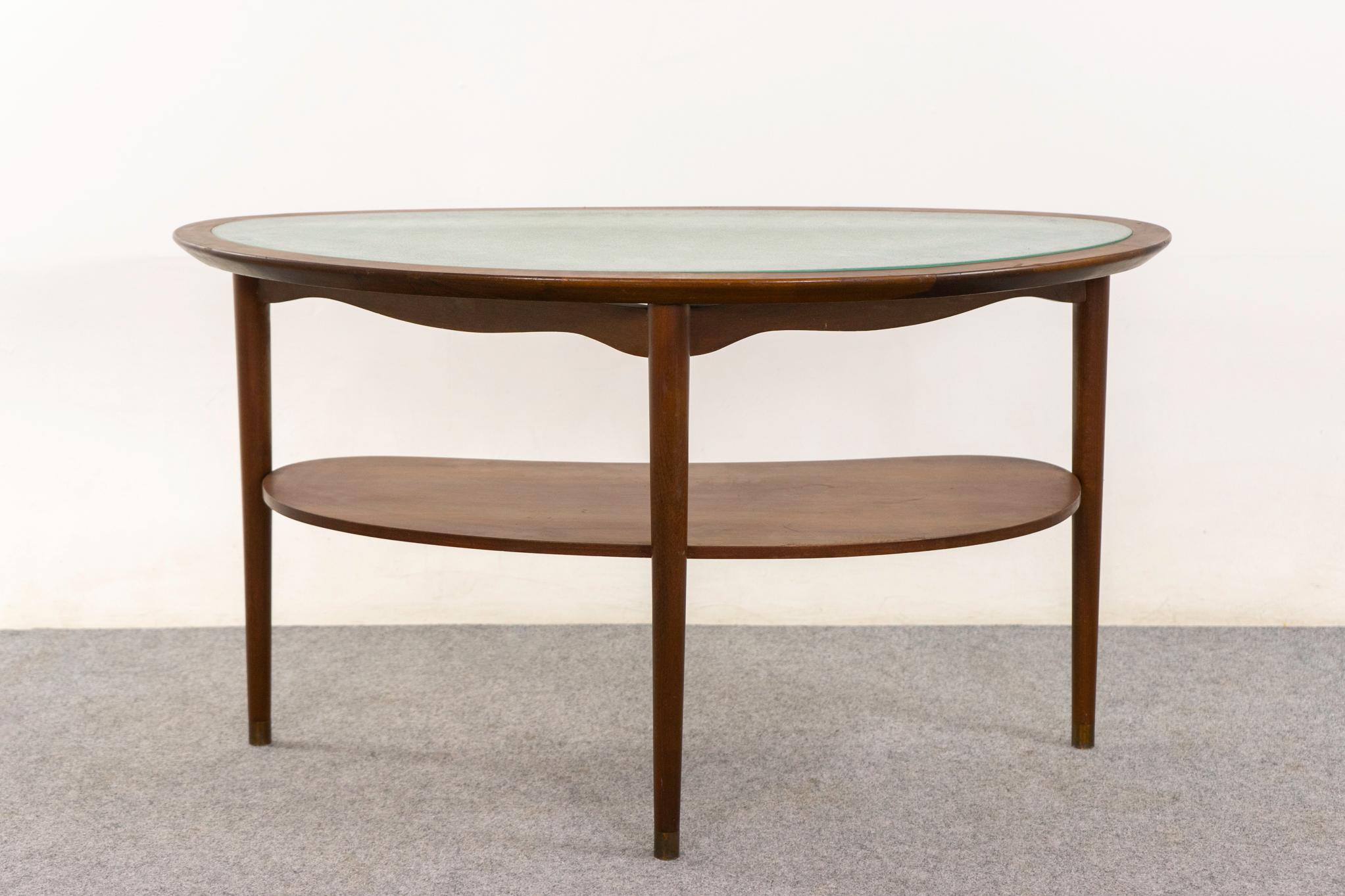 Table d'appoint danoise en noyer et verre, circa 1960. Forme arrondie unique en demi-cercle avec dessus en verre gravé décoratif, tablier festonné et étagère pratique.   

Pièce non restaurée avec option d'achat en condition restaurée pour un