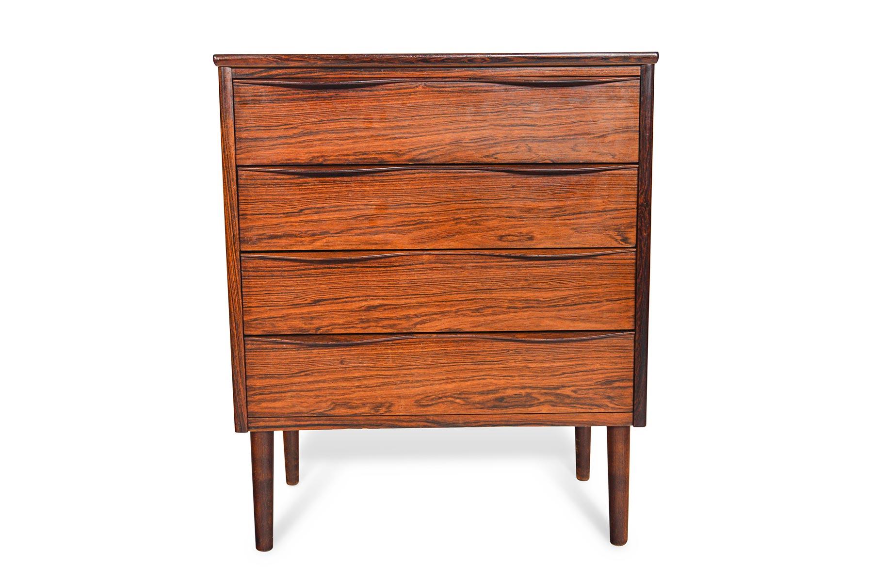 This Danish modern midcentury rosewood entry chest offers excellent storage in a tall, stately silhouette. Each drawer features a carved wave pull design. Case stands on stained beech legs. In excellent original condition.

 