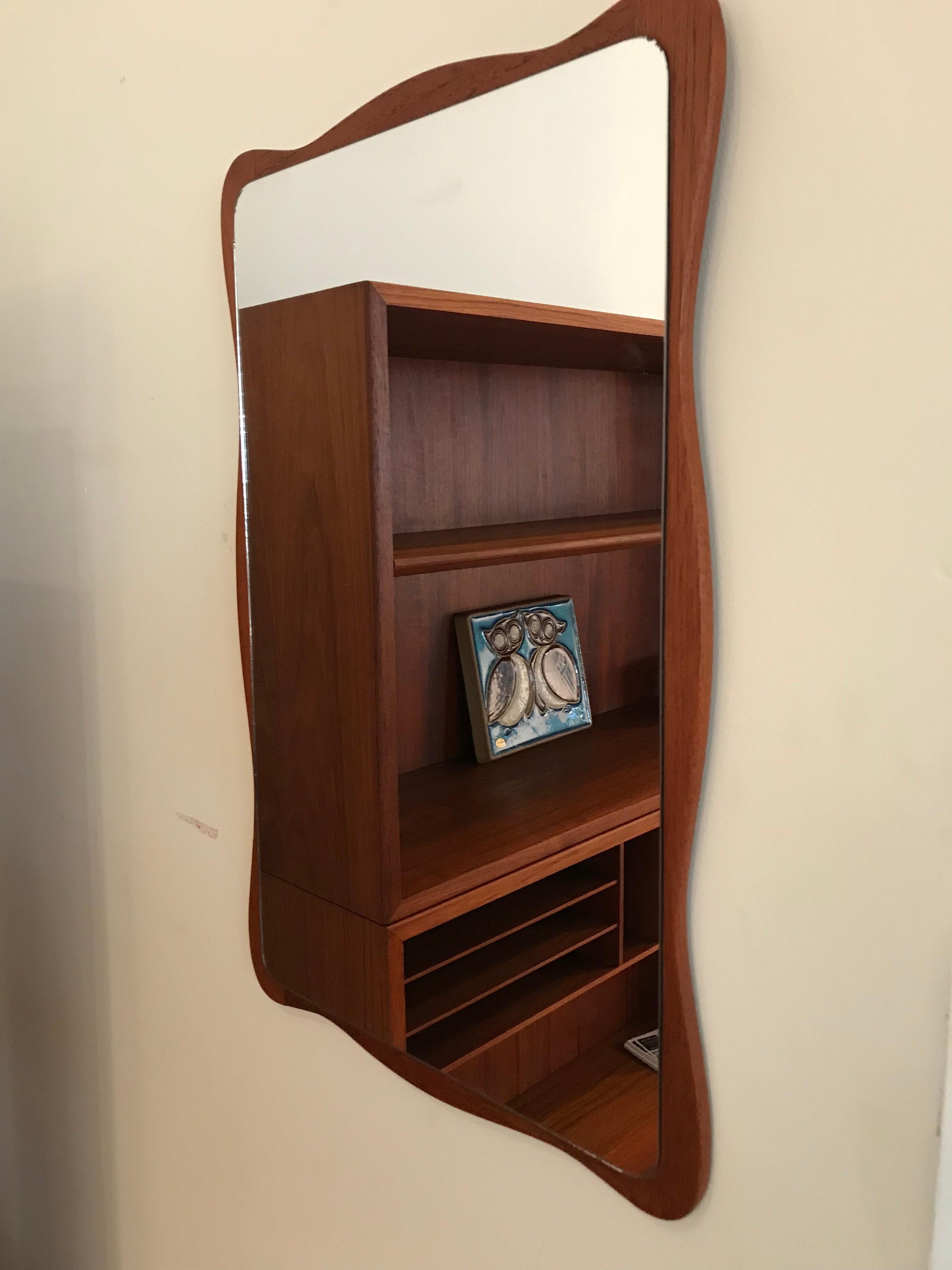 Unusual wavy edged midcentury teak mirror. Would look great in a hallway or a above a side table.