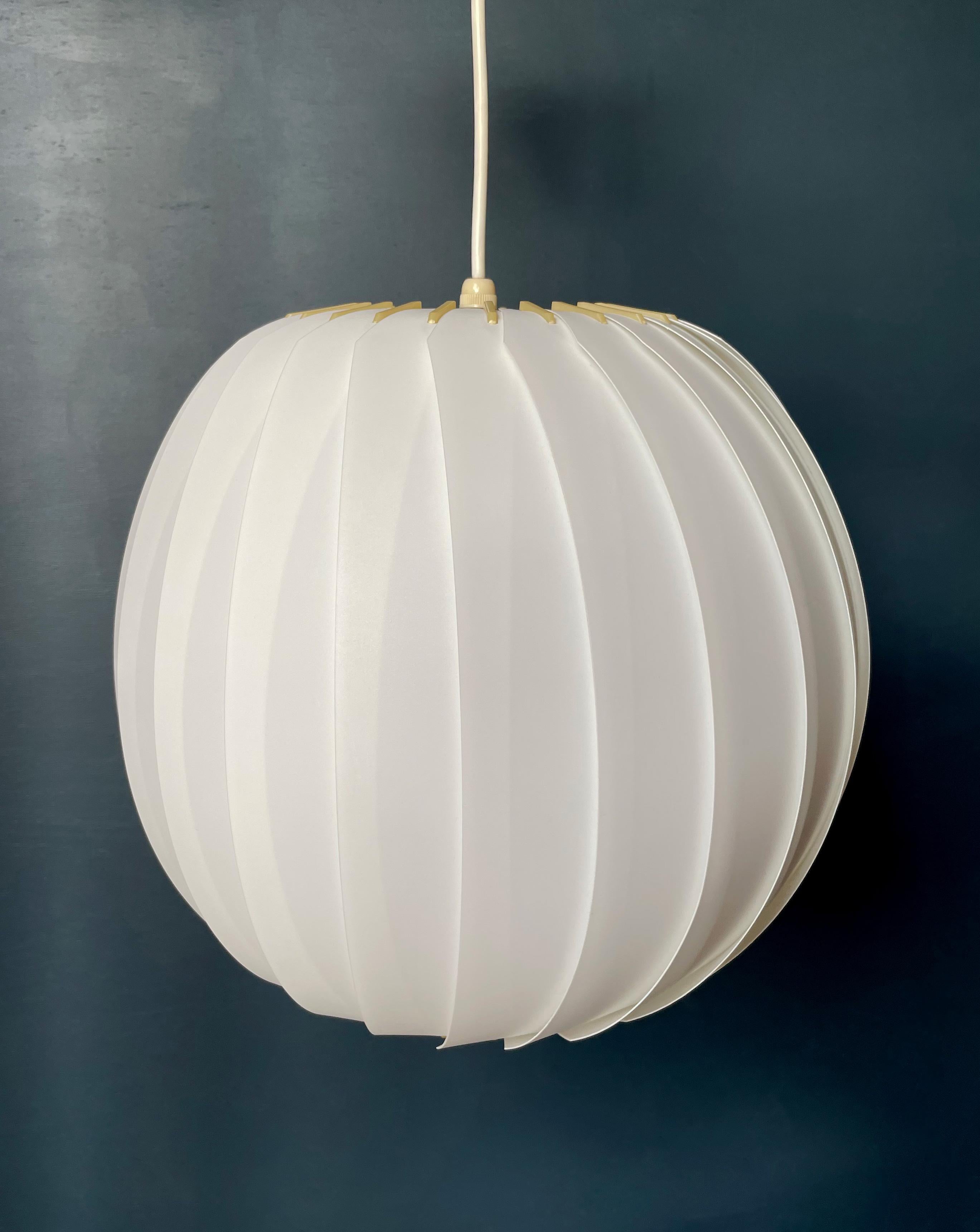 Minimalist Scandinavian Mid-Century Modern white acrylic pendant consisting of layered white, textured strips gathered on top and bottom with cream yellow acrylic strips. Designed in 1972 by Lars Eiler Schiøler (1913-1982) for Høyrup Light. Model