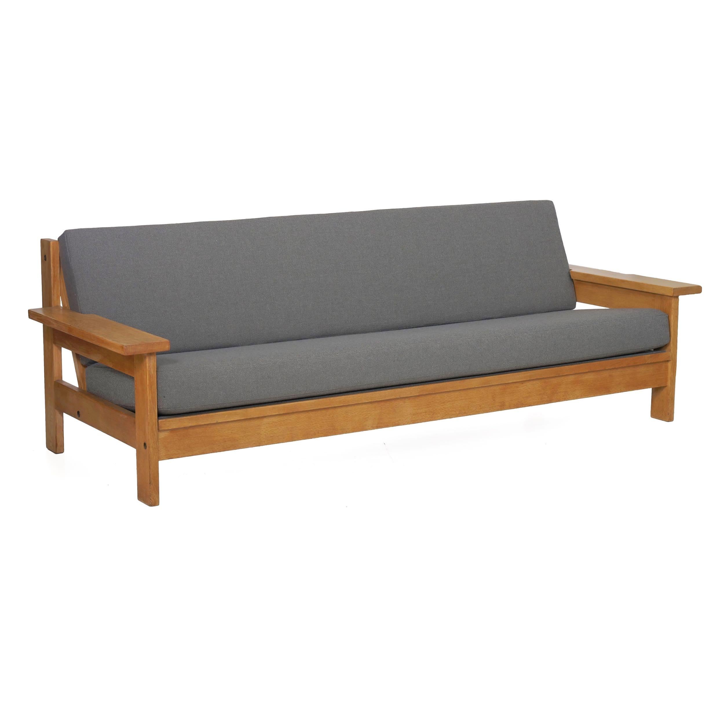 A sleek and angular three-seat sofa of excellent quality, this piece is executed in solid white oak that has a lovely faded and mellowed appeal in the natural open grain. Stark simplicity rules the form, which is somewhat reminiscent of a modernized