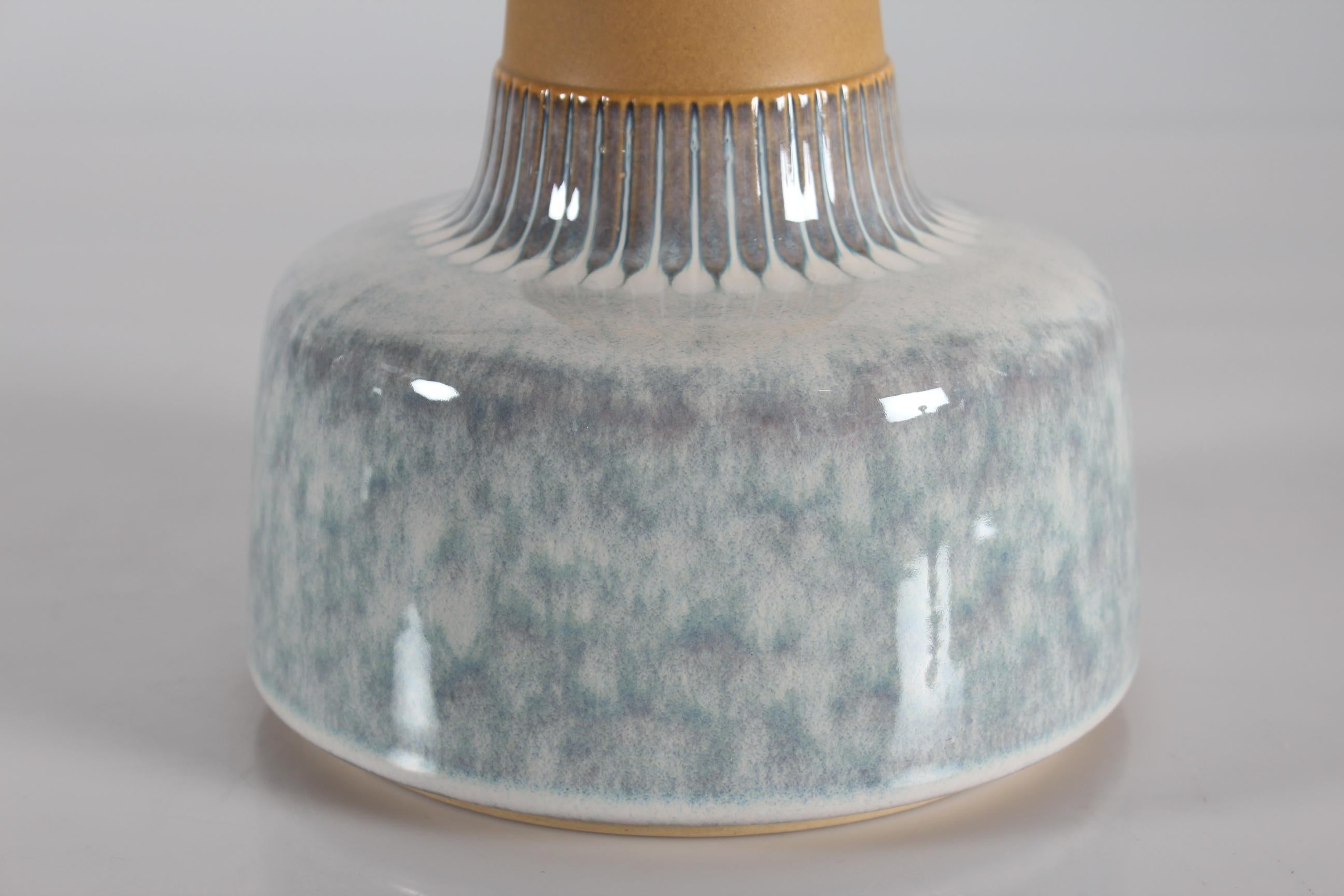 Midcentury tall table lamp by Danish stoneware manufacturer Søholm, designed by Einar Johansen and produced in the 1960s

The bottom part of the lamp has a glossy glaze of mixed light blue, white and grey colors changing into a more well defined