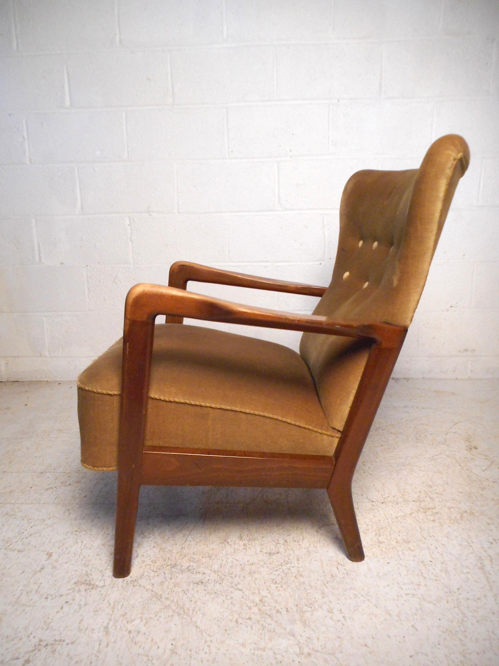Impressive Danish modern chair designed by Soren Hansen for Fritz Hansen, circa 1950s. Featuring a tall winged back with tufted upholstery, a sleek angular wooden frame with sculpted armrests, and vintage upholstery. An impressive addition to any
