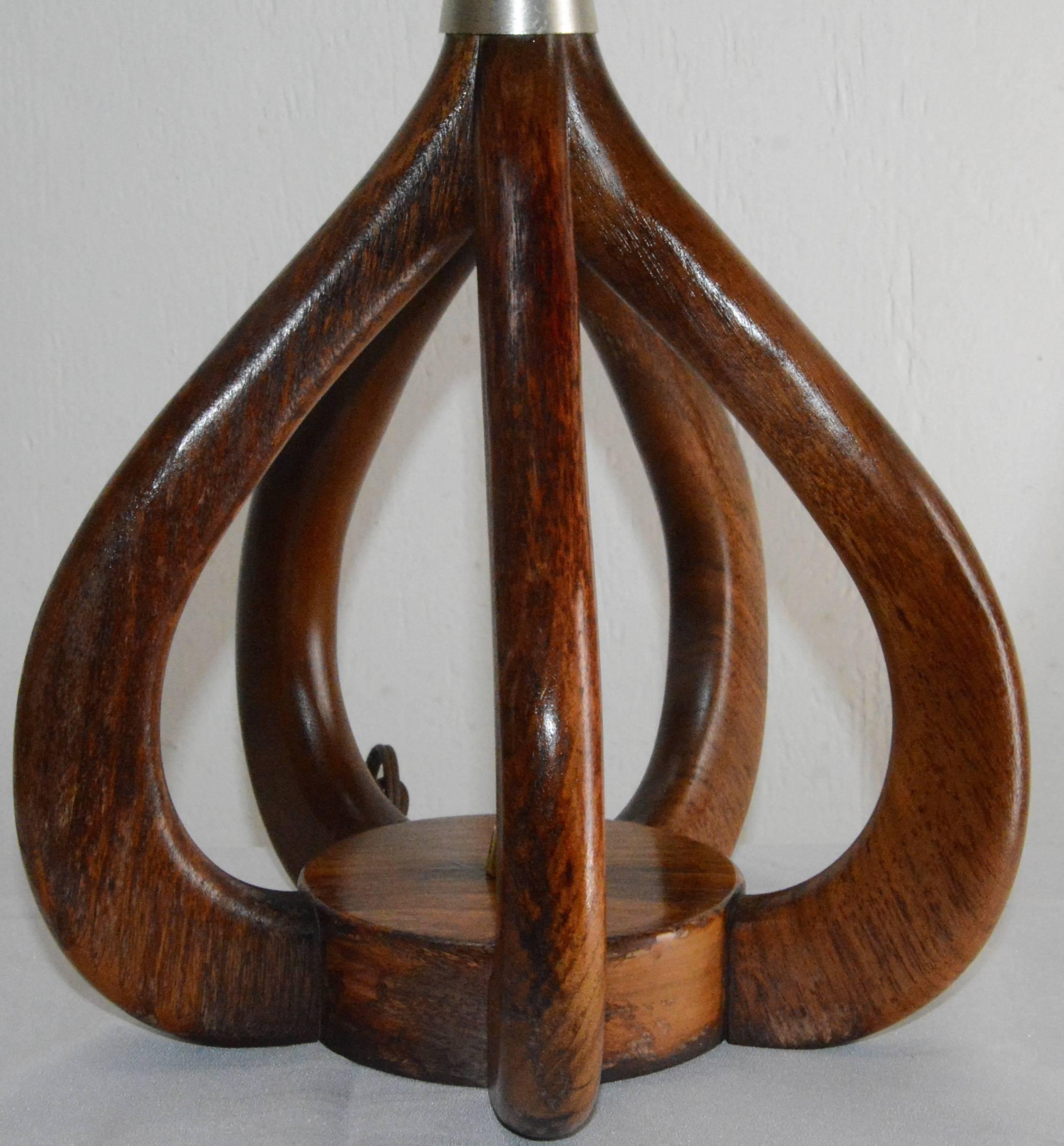 Up for your consideration is a nice vintage Woolums Danish modern wood and metal table lamp. The lamp has a brass finish cap finial, harp and centre pole. Other features of the light include a tapered brushed silver finish centre body on curved teak