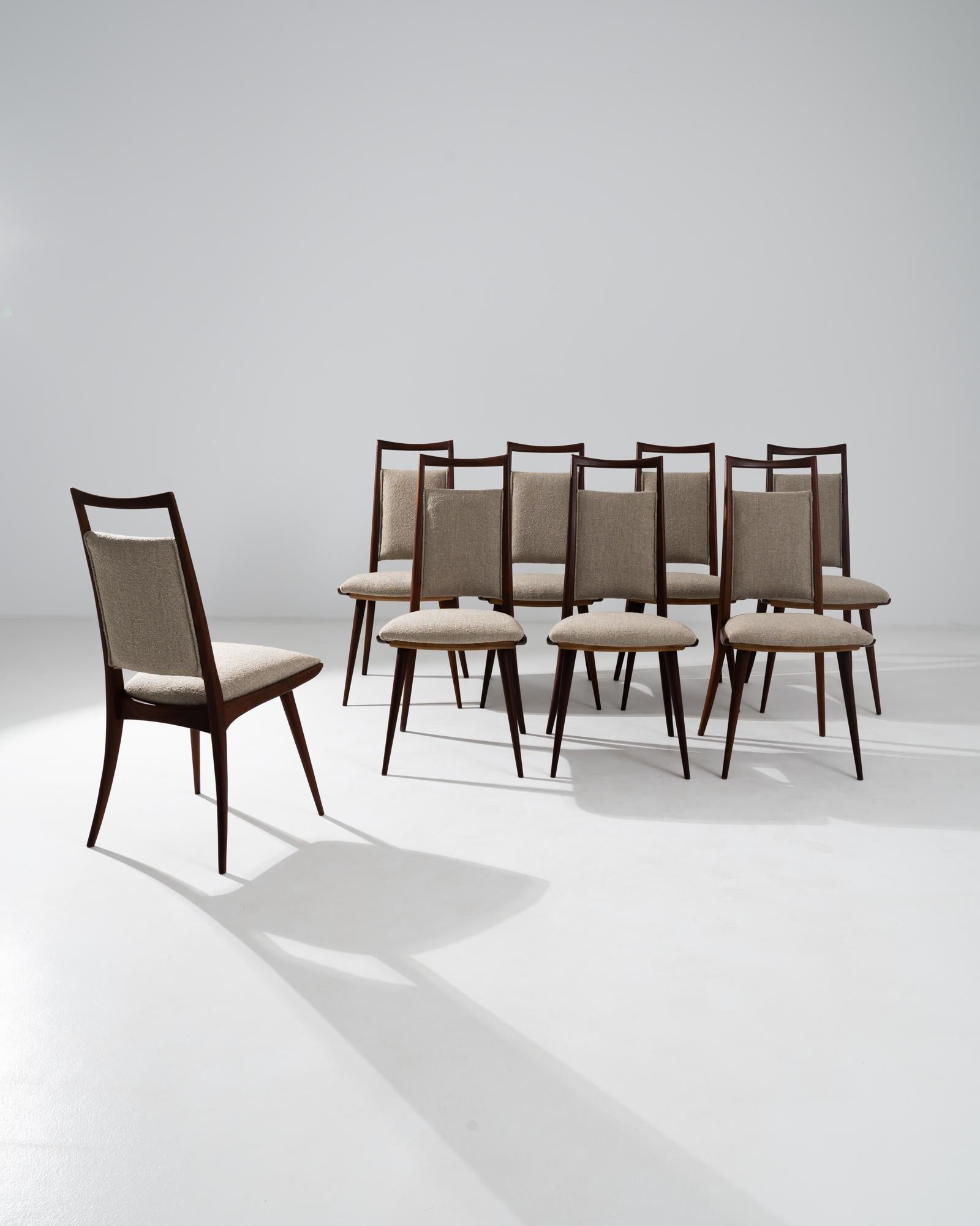 A set of wooden upholstered dining chairs from 20th century Denmark. Known for its mastery of midcentury design, these Danish-made chairs do not disappoint in construction or style. Dark, gleaming wood, angled just so into gently sloping curves,