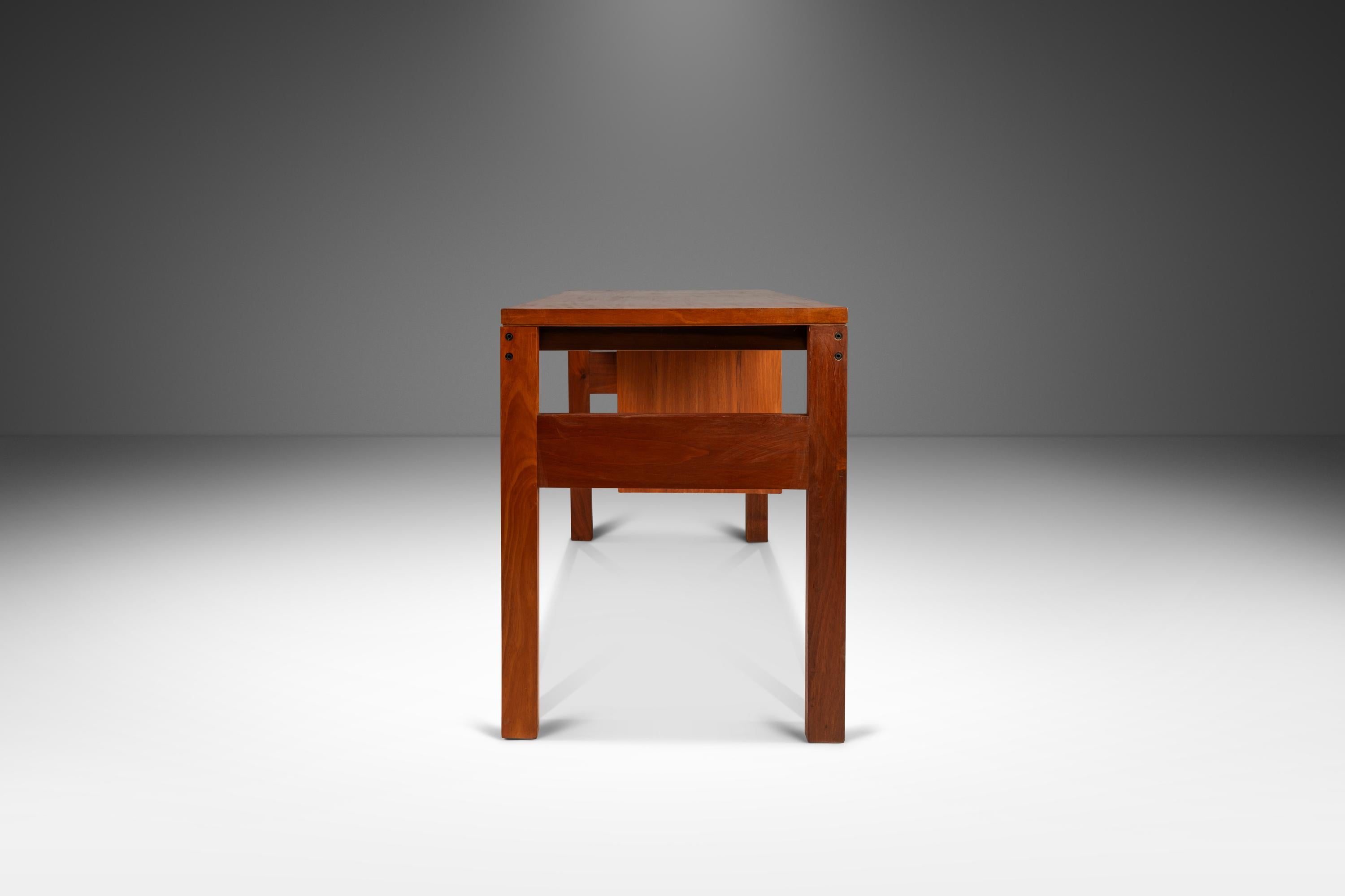 Introducing a splendid Danish Modern writers desk constructed from a mix of solid and veneered Burmese teak with exceptional woodgrains. Featuring three drawers with handles carved out of solid teak, even the drawer side walls and sliders are built