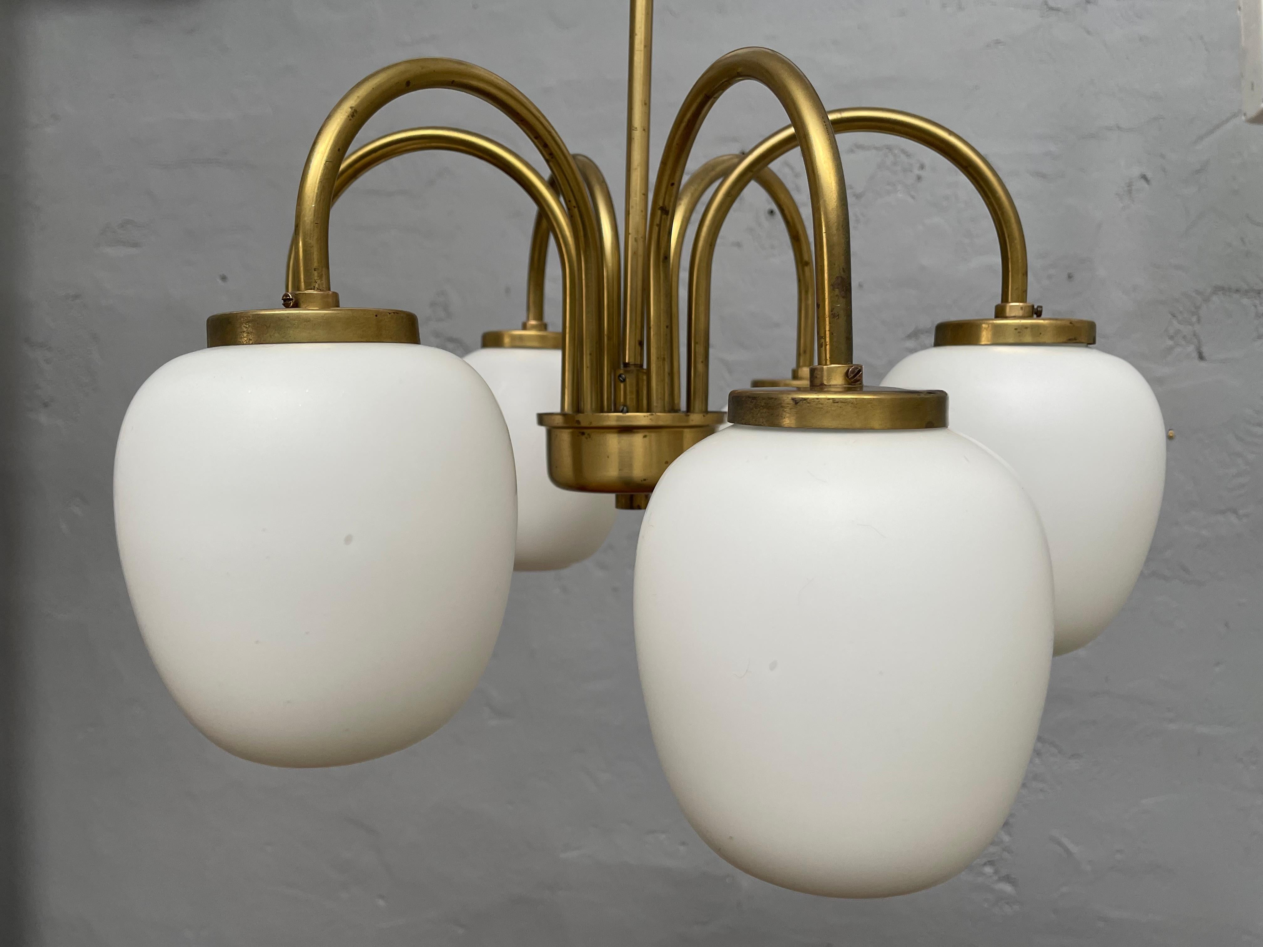 A beautiful Danish classic mid century modernist brass chandelier pendent by Lyfa and with hand blown opaline glass shades. 
Age related wear and patina to the brass surfaces. 
The chandelier has been dismantled all parts cleaned and not polished.