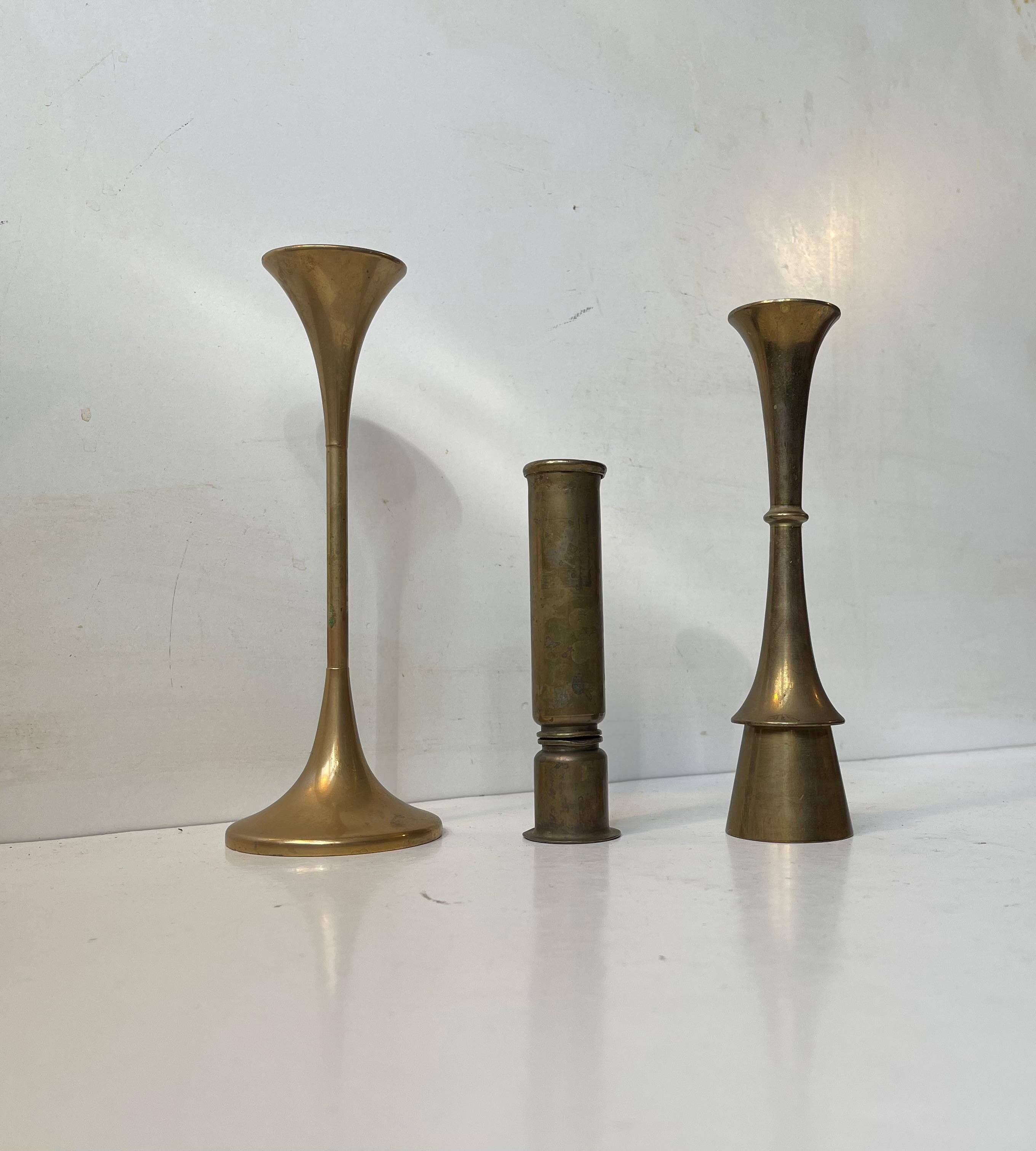A trio of brass candlesticks manufactured in Denmark during the 1960s. The candlesticks are to be fitted with regular sixed candles. They have not been polished recently and display patina. The style of this set is reminiscent of Quistgaard, Hans