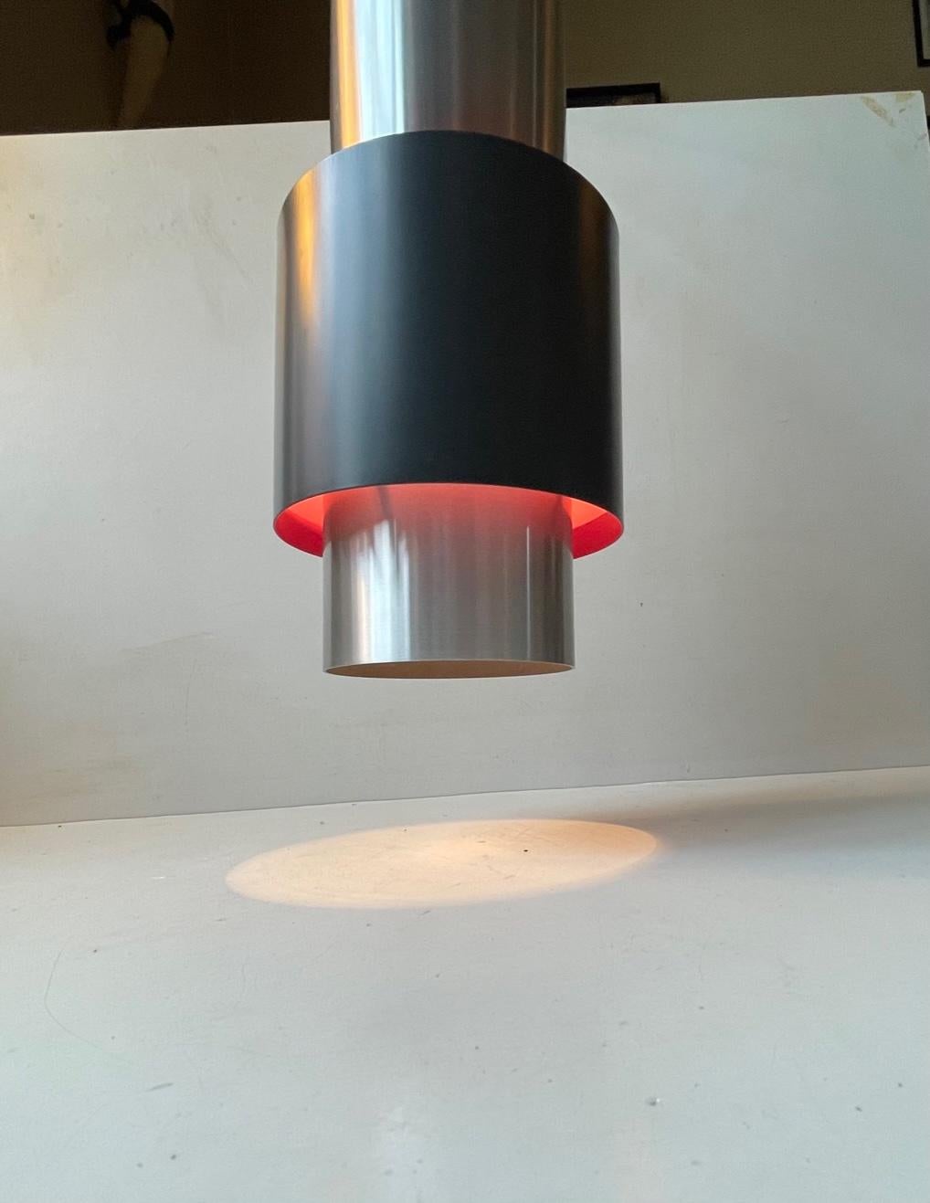 Large cylindrical space age pendant lamp made from brushed aluminium set with a slate black shade with purple interior. This purple turns in to pink when lid. Its called Zenith and was designed by Jo Hammerborg and manufactured by Fog & Mørup in