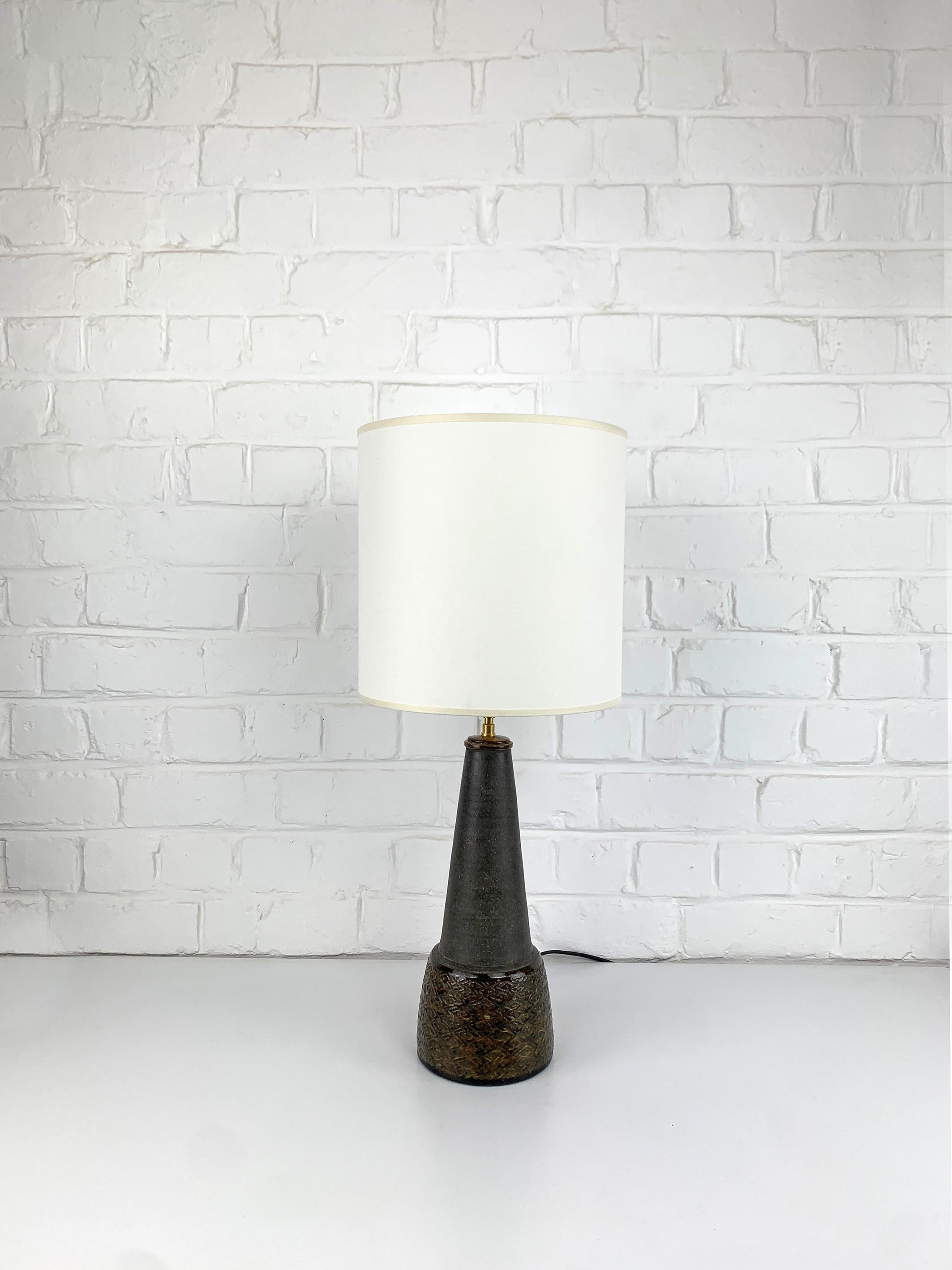 Stoneware table lamp finished in a combination of a dark uranium yellow / ocre glaze and natural dark brown stoneware finish. The lower glazed part is decorated with an impressed pattern.

Designed by Nils Kähler in the 1960s or 1970s. Manufactured
