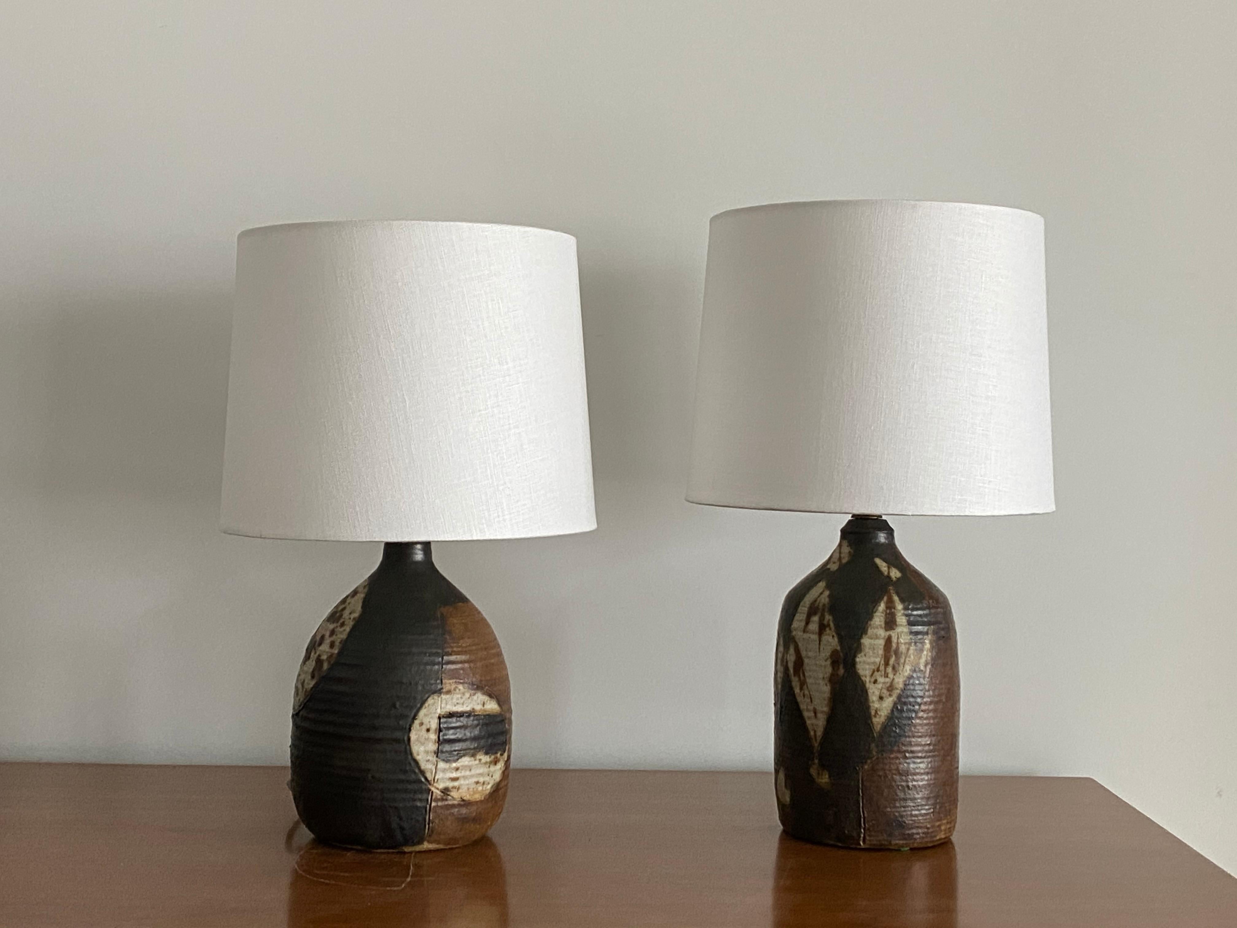 A pair of table lamp produced by an unknown modernist ceramicist. In highly artistic glaze. Signature on underside. Stated dimensions of highest example, with lampshade mounted.

Other ceramicists of the period include Axel Salto, Arne Bang,
