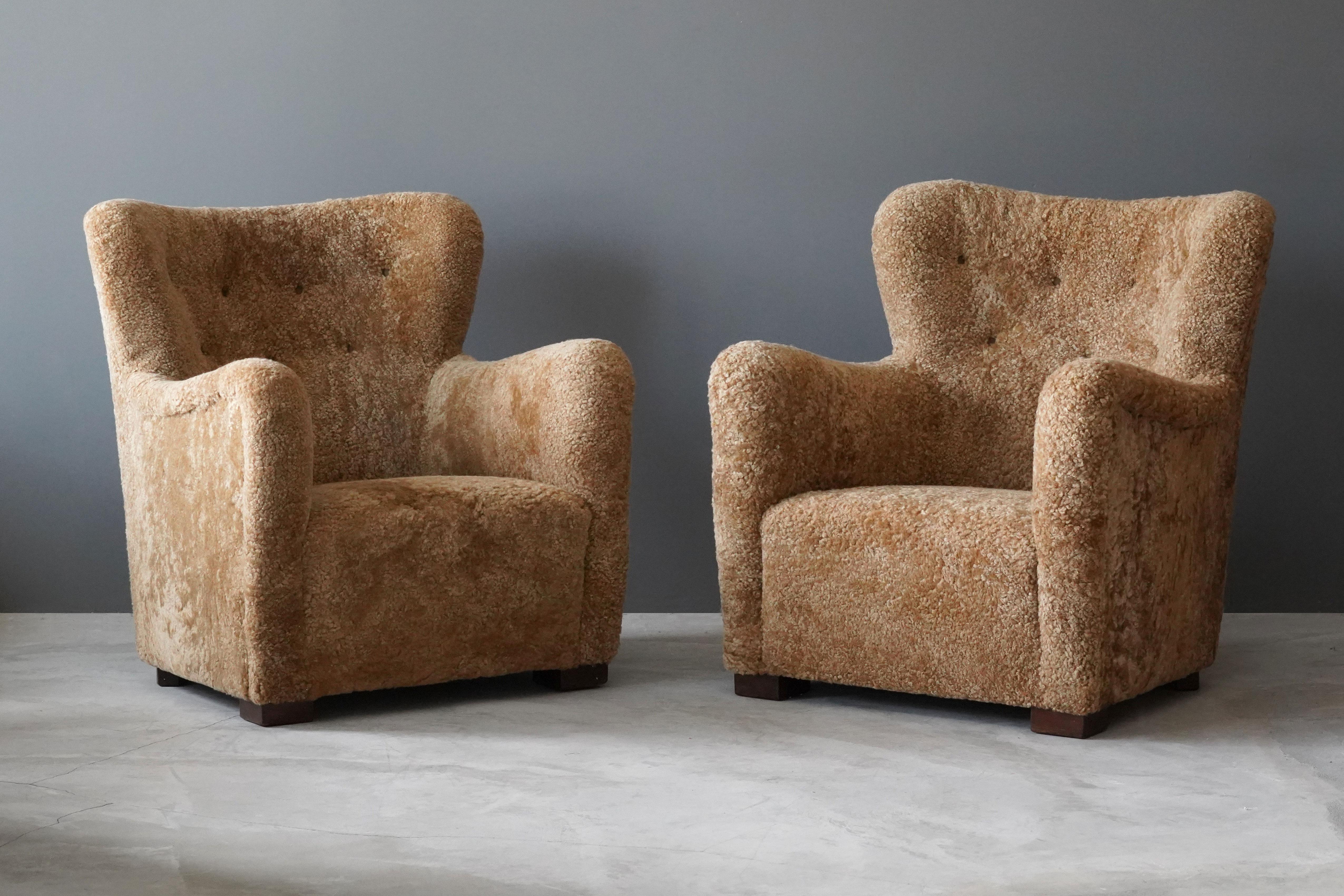 A pair of organic lounge chairs / arm chairs, designed by an unknown danish designer, 1940s, Denmark. Reupholstered in brand new authentic sheepskin / shearling / lambskin.

In the manner of Flemming Lassen or Viggo Boesen.