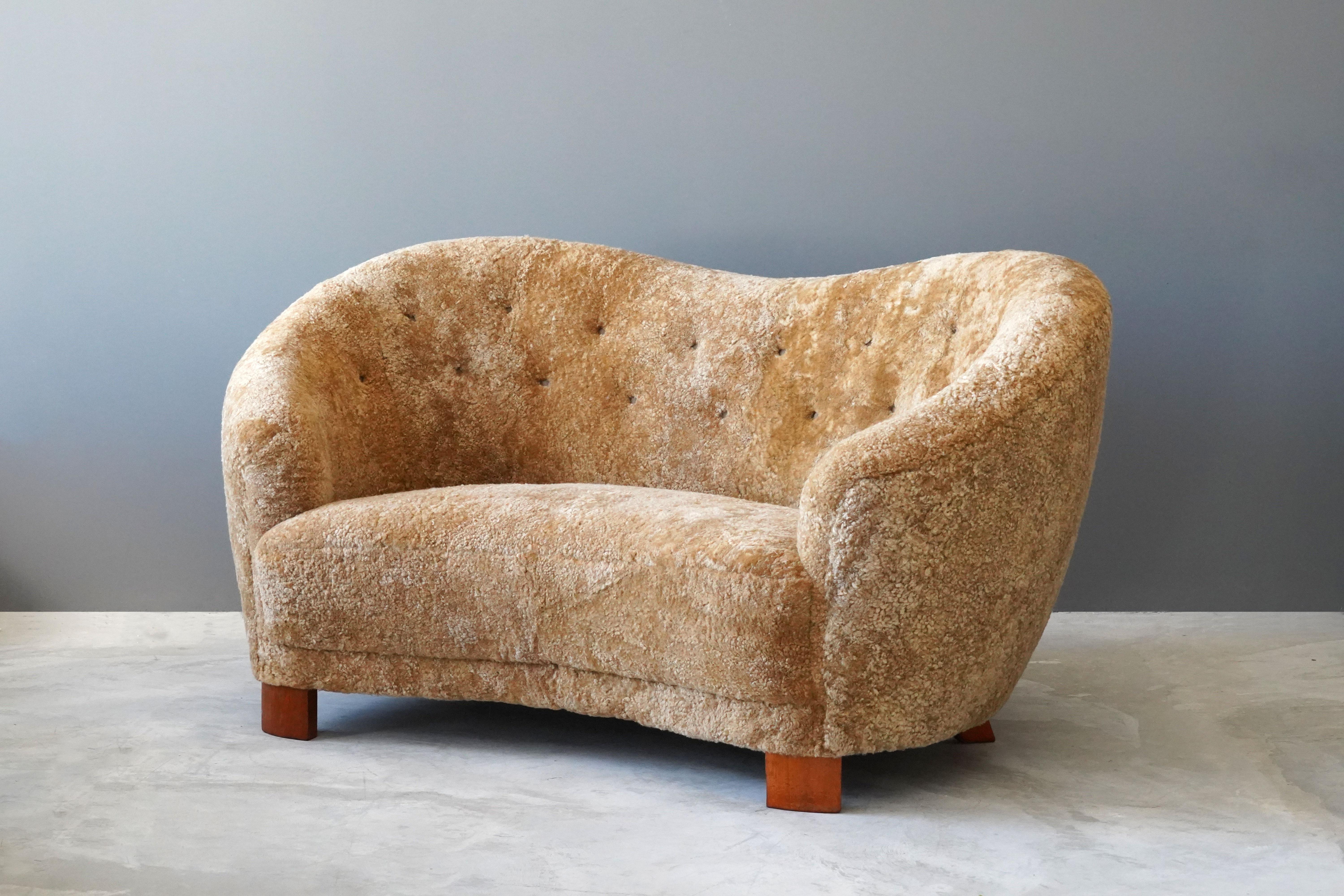 An organic modernist sofa / loveseat / settee. Produced in Denmark, 1940s. Reupholstered in brand new deep beige authentic sheepskin / shearling. 

Shares it's origin and organic style with works by designers such as Viggo Boesen, Flemming Lassen,