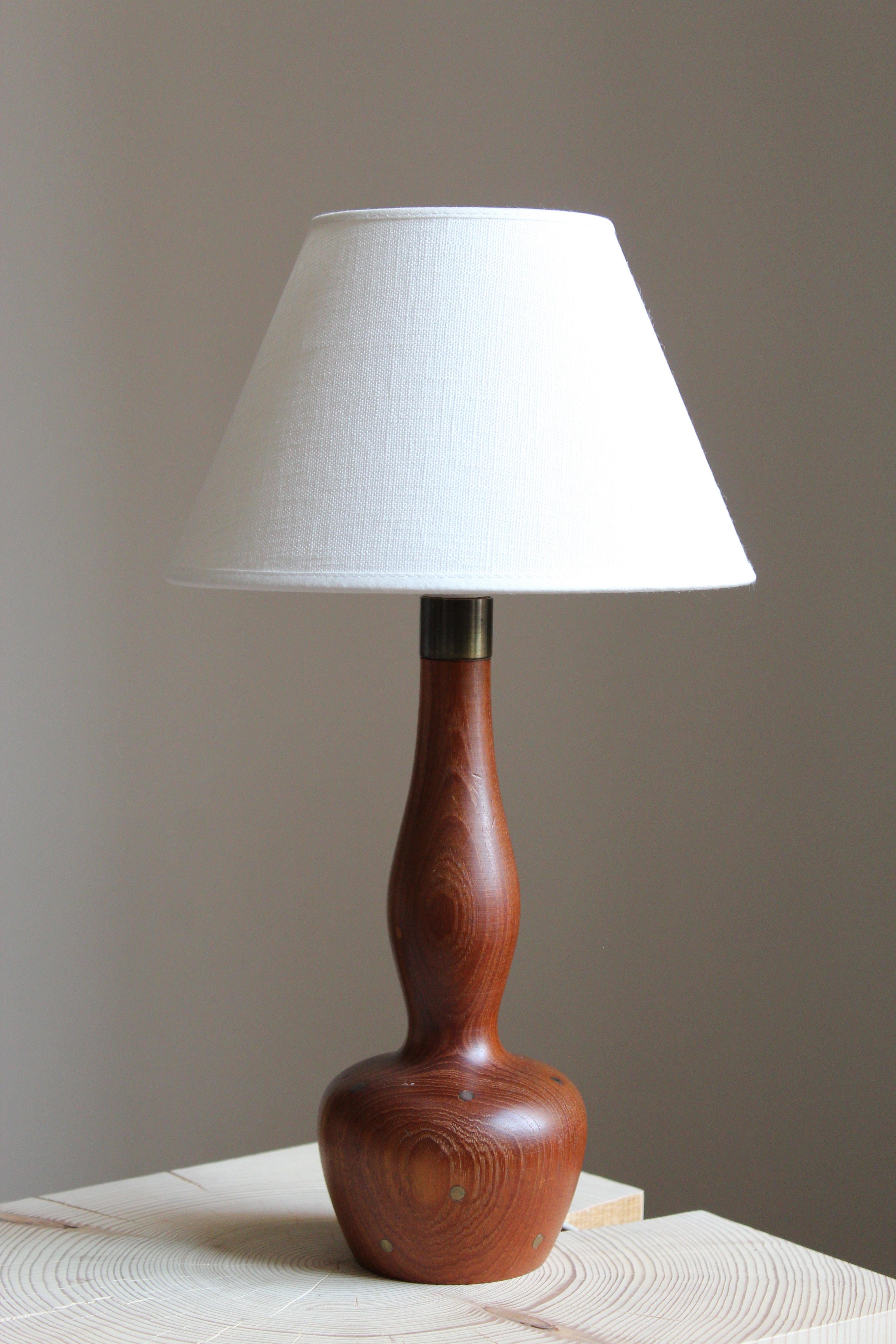 An organic table lamp. In solid teak, with superb brass inlays adding further appeal. Brand new linen lampshade.

Other designers of the period include Finn Juhl, Hans Wegner, Kaare Klint, Alvar Aalto, and Paavo Tynell.