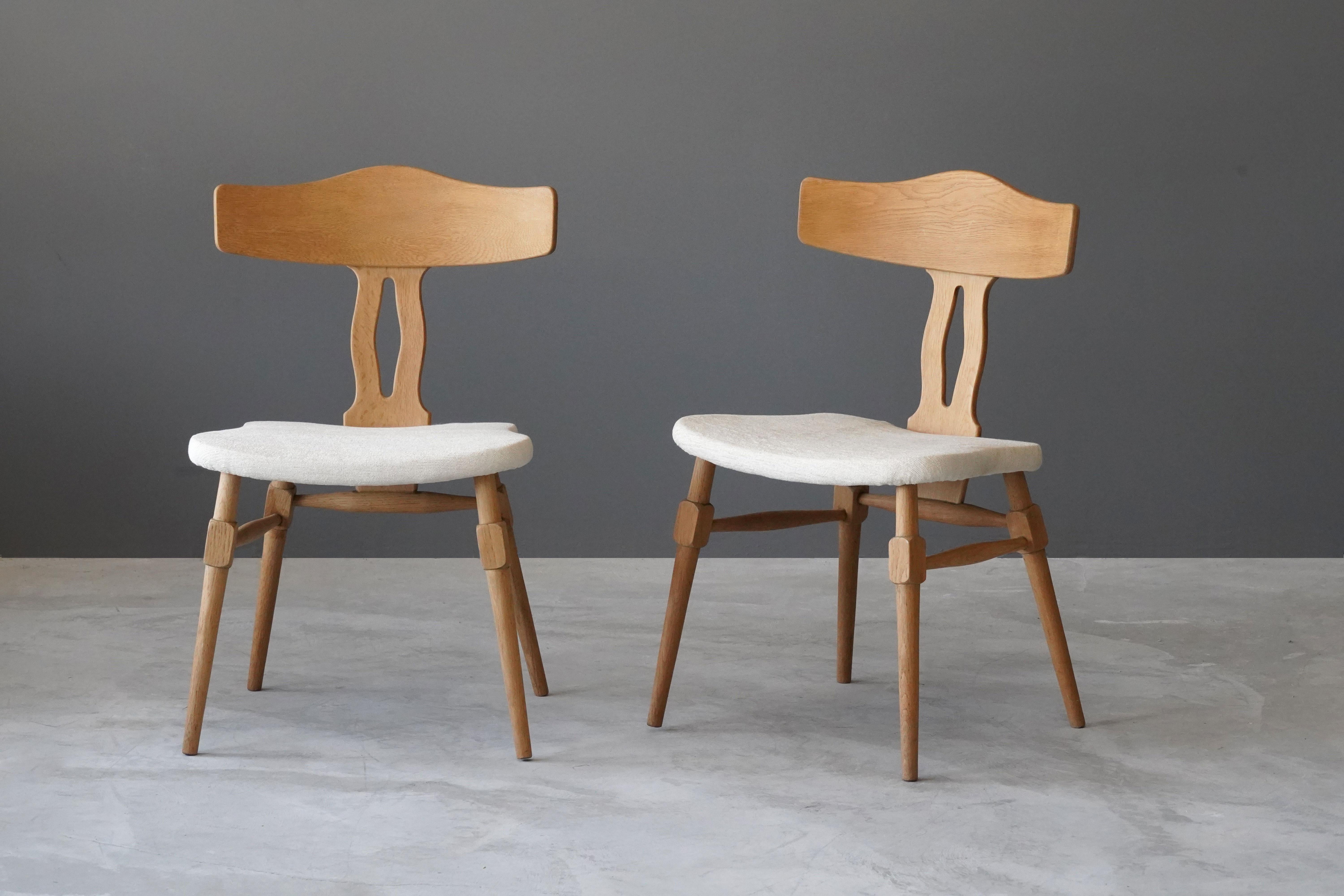 A pair of side chairs by an unknown Danish designer. Produced in Denmark, 1960s. 

The carved and joined oak frame is paired with an organic overstuffed seat. Newly reupholstered.

Other designers of the period include Kaare Klint, Philip